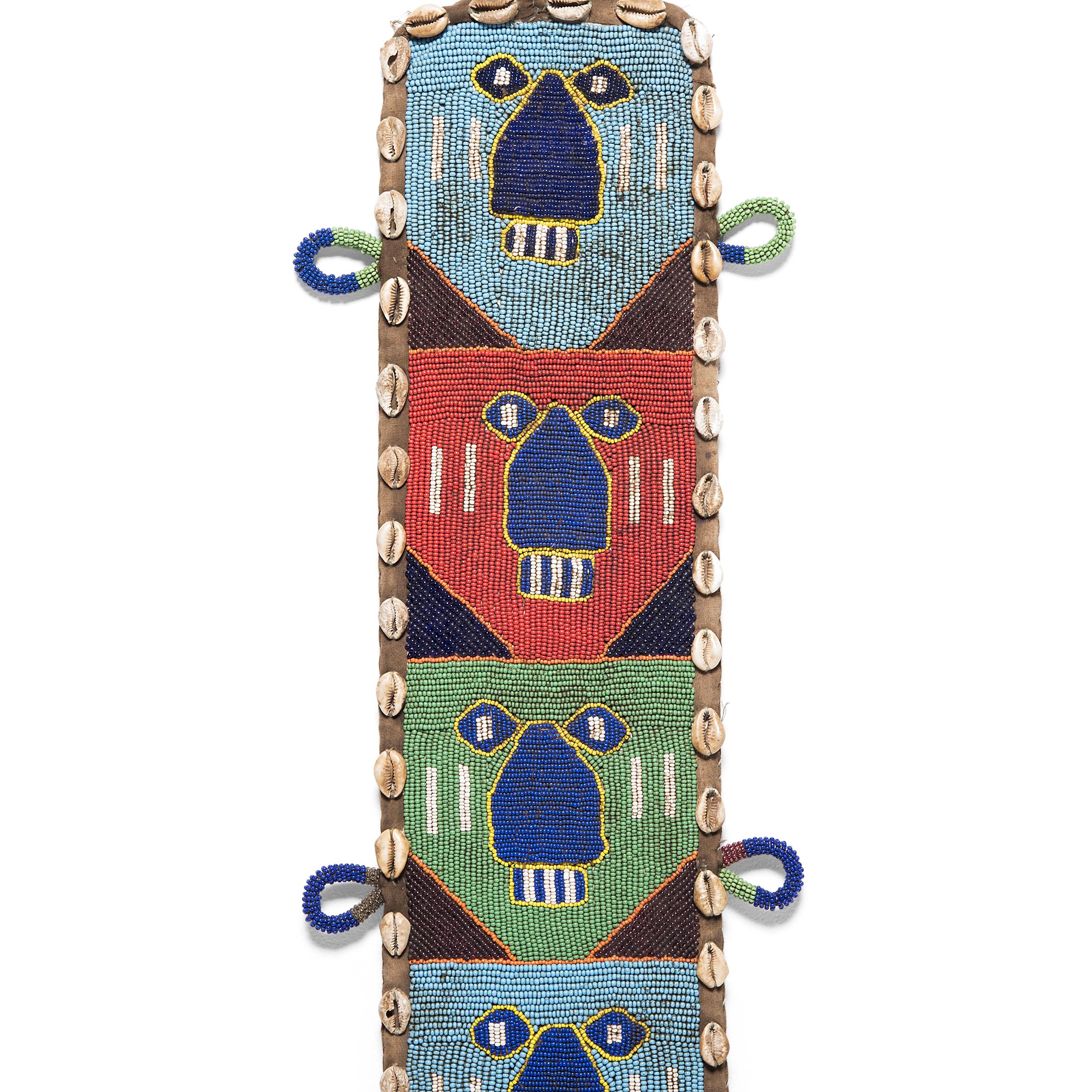 This intricately-constructed colorful train was painstakingly created by Yoruba artisans in Nigeria in the mid-20th century. Recent designs such as this were based upon sashes that signified the owner's spiritual position within the community and