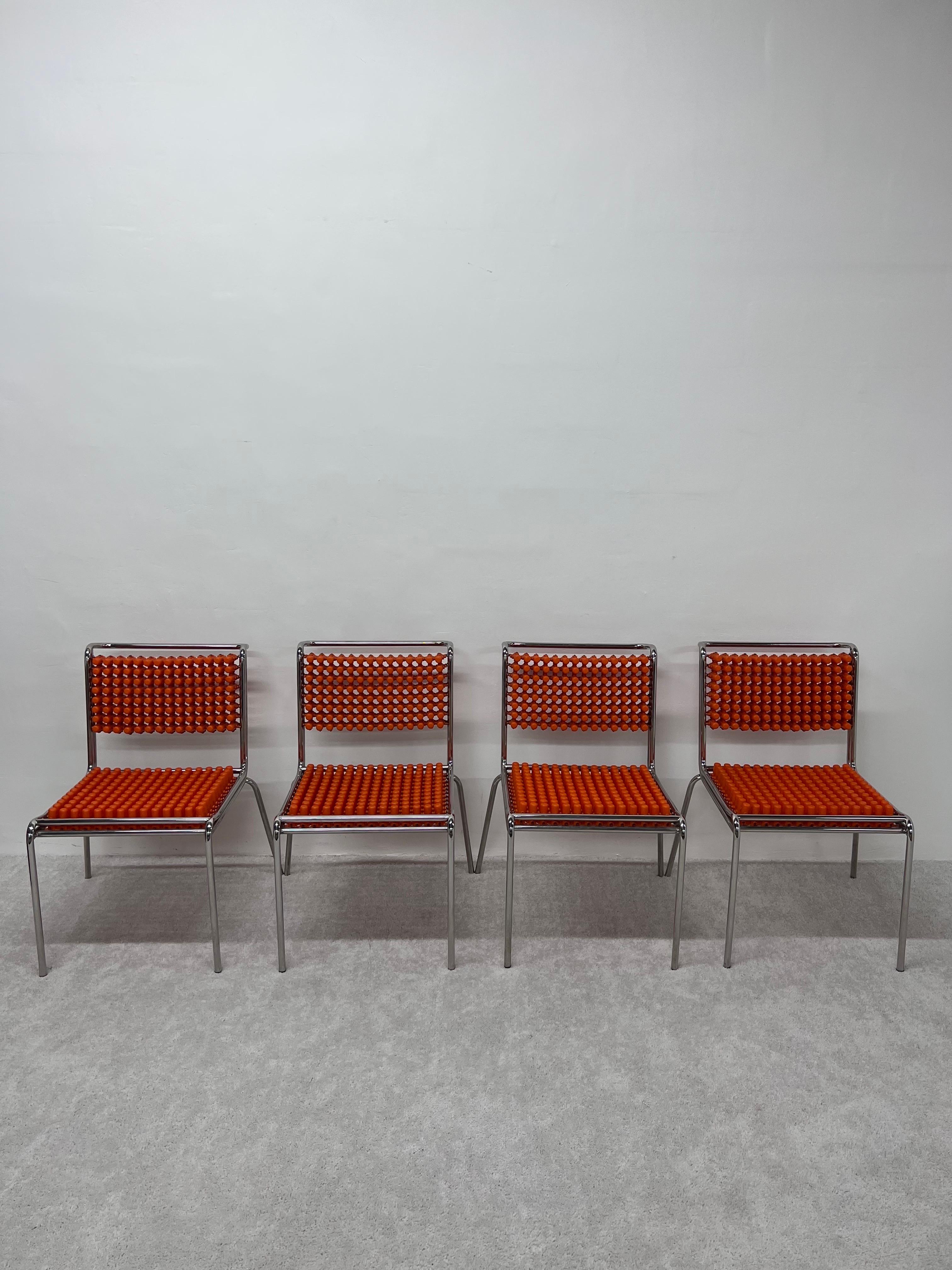 Set of four Origin Series stackable dining chairs with chrome frames and orange polypropylene “capsules” braided by sandows designed by father and son duo Yos and Leonard Theosabrate for Accupunto.

Inspired by an ancestral method of acupuncture,