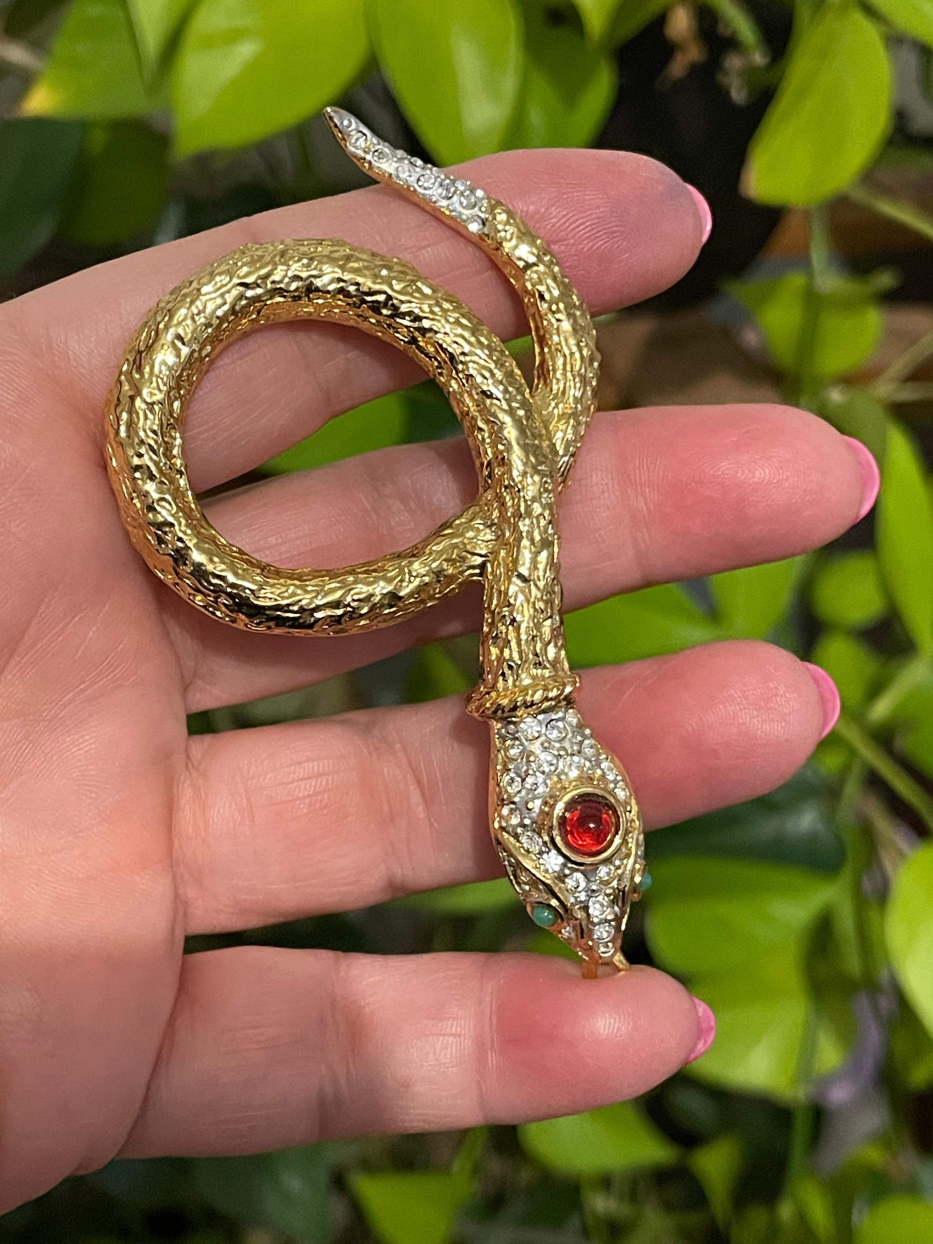 Crystals set in the snake head and its tail Green Cab eyes with a Reddish Cab on the top of the head' The snake is Wrapped up around itself. Very Cool Statement piece. Measures 3.46 inches x 1.90 inches top to bottom...Visit our store front for