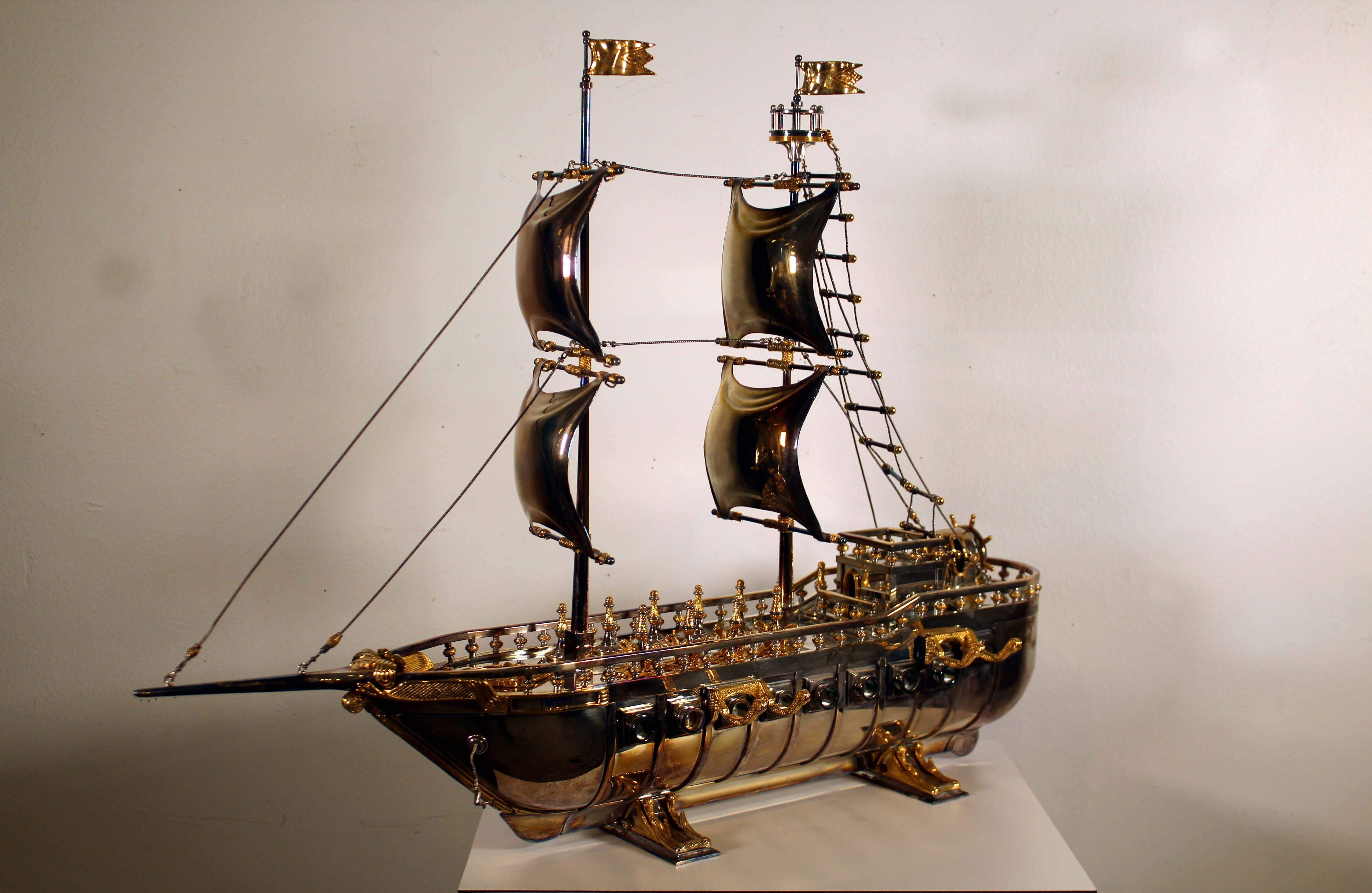 A magnificent square-rigged ship-form Hanukkah menorah with elaborate mechanical workings, turning ship's wheel glides cannon from starboard side operating inner silver gears, eight of the nine cannon handles on deck lock and unlock each cannon