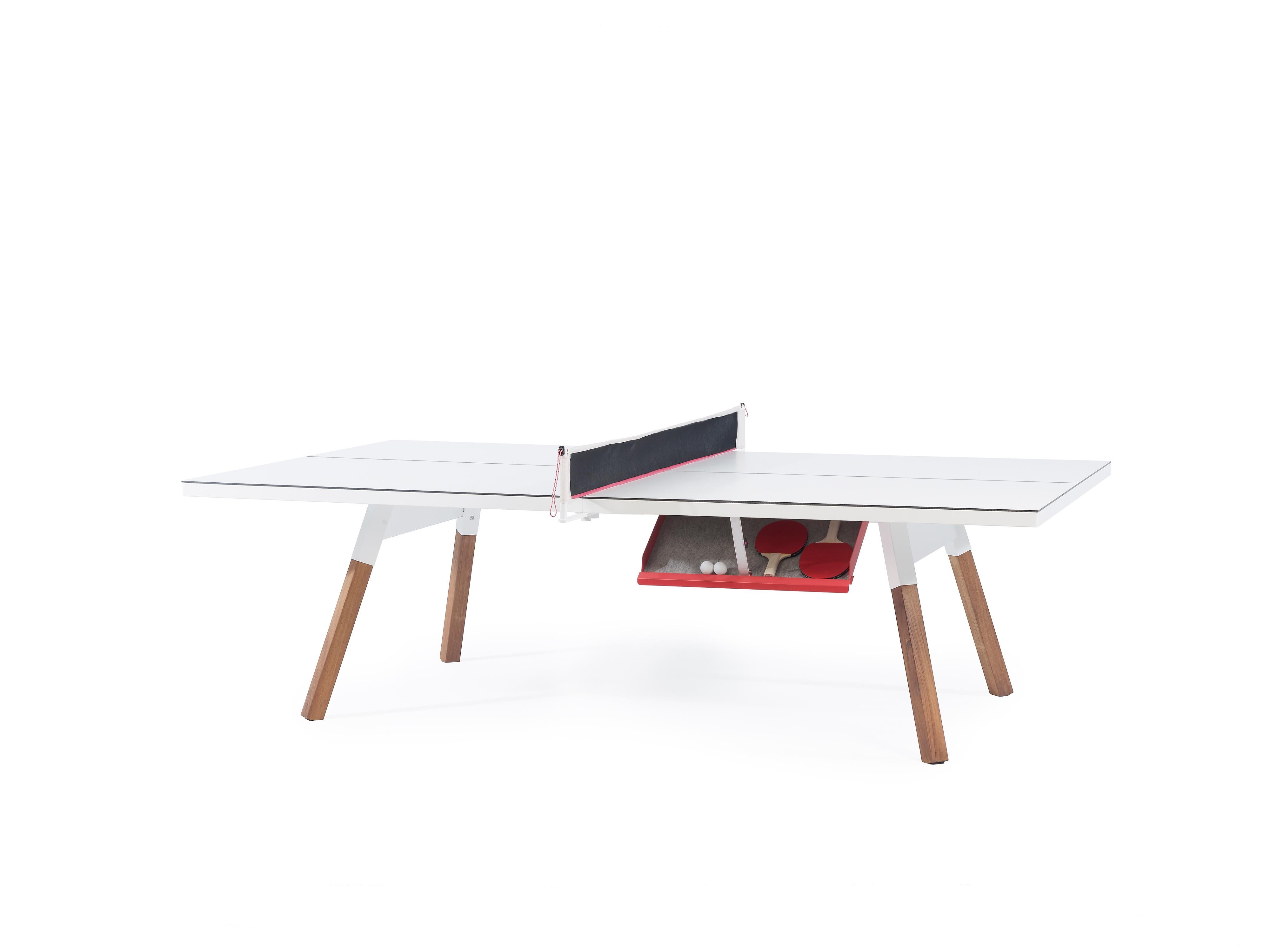 The  You and Me ping-pong table is a standard sized game table that doubles as a dining or conference table. All the sportiness that it gets from the net, the bats, and the balls, can be put in the side drawer and hidden away completely. Built from
