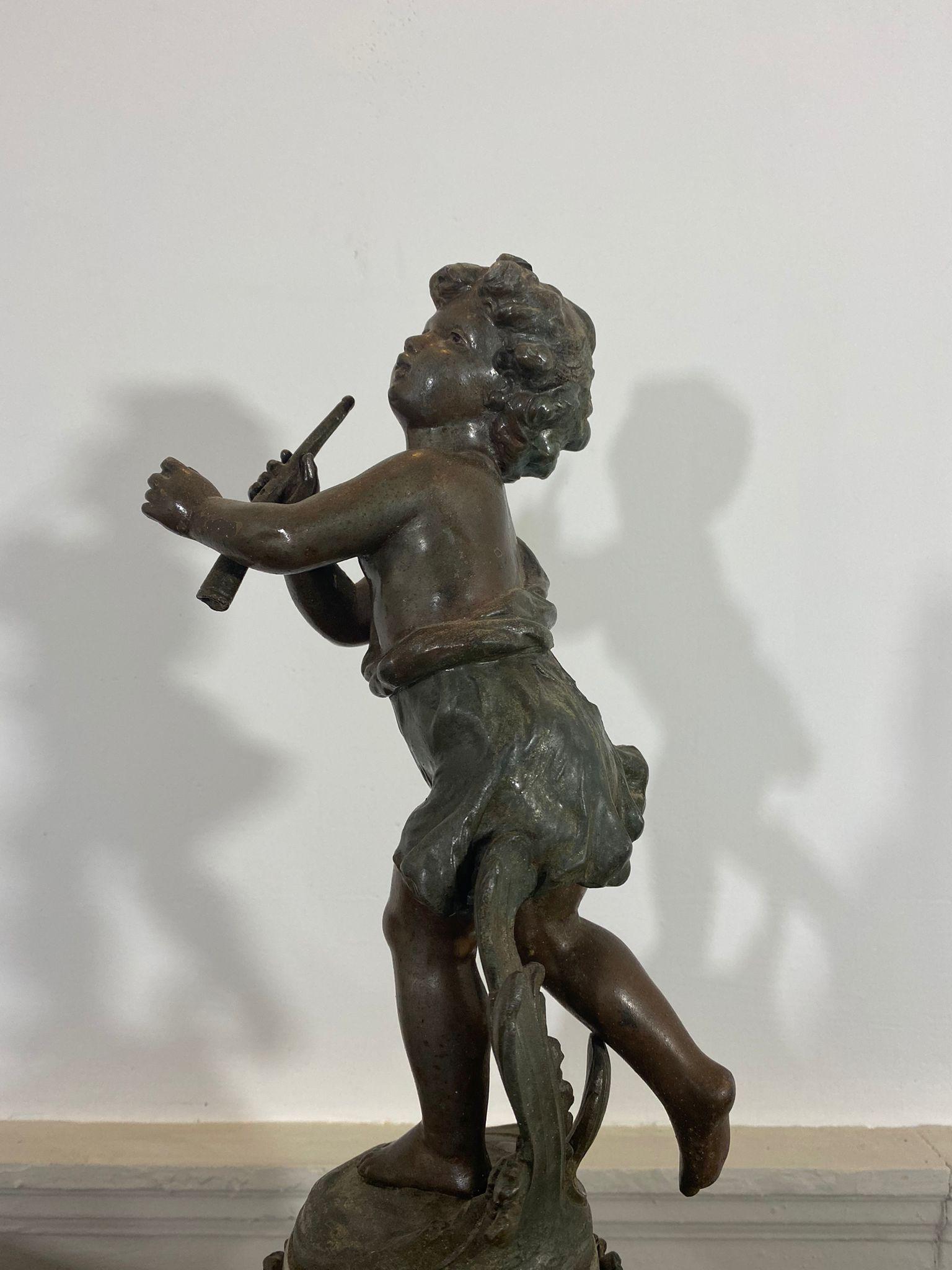 Charmante Skulptur aus Zinn mit Bronzepatina, im Stil von Auguste Moreau, die einen jungen Flötenspieler in Landhauskleidung darstellt, der seine Flöte in der linken Hand hält und in Bewegung zu sein scheint (durch die Position seiner Beine und den