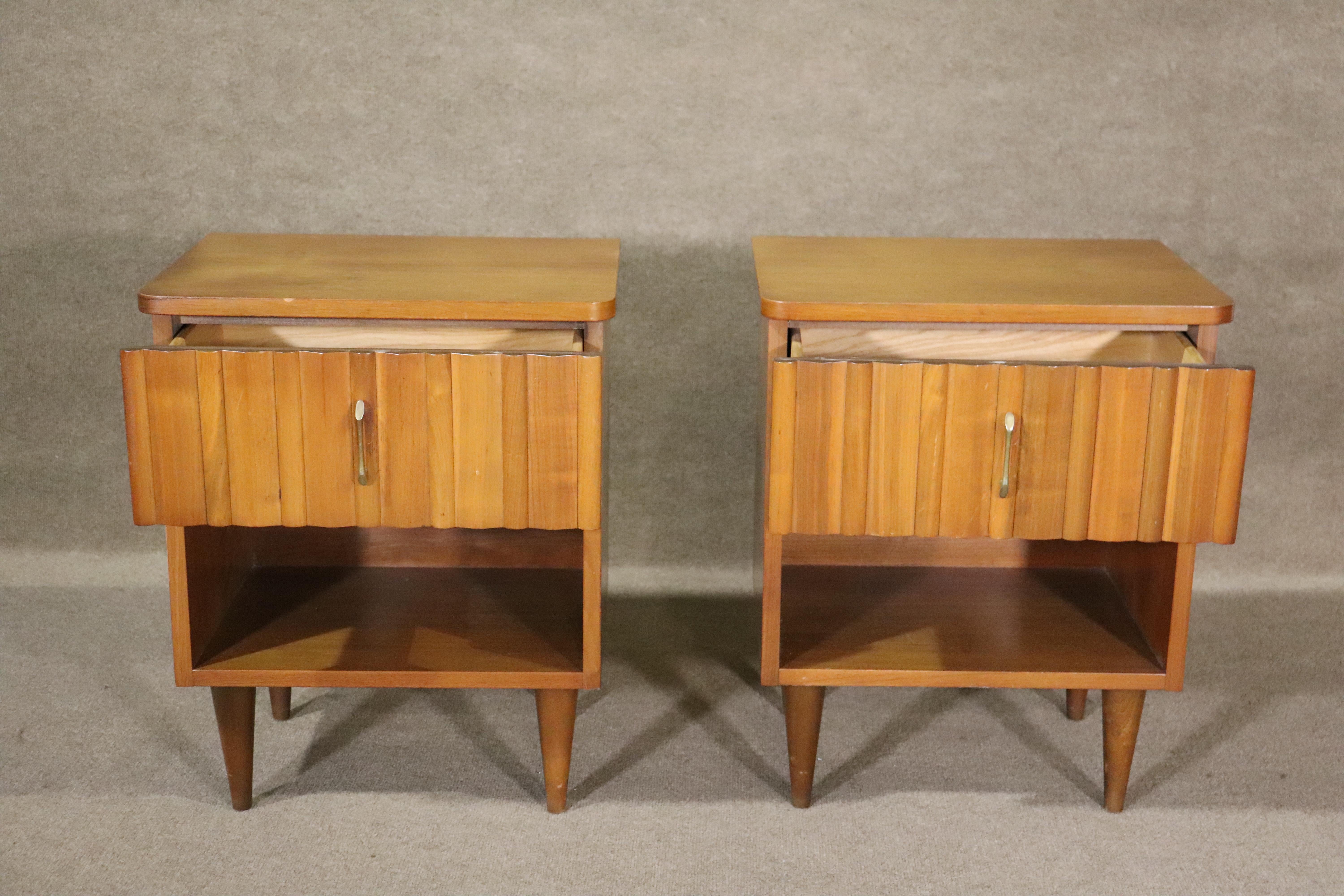Pair of walnut wood single drawer end tables with brass handles. Produced in the 1960s by Young Manufacturing Company, featuring cone legs and sculpted front drawers.
Please confirm location NY or NJ