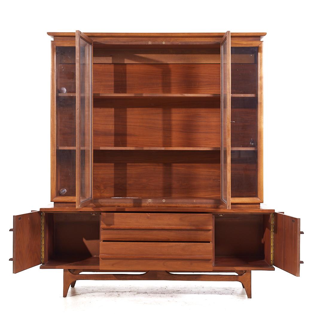 Young Manufacturing Mid Century Walnut Curved Credenza and Hutch

The credenza measures: 64 wide x 19 deep x 24.75 inches high
The hutch measures: 61.5 wide x 13.25 deep x 49 inches high
The combined height of the credenza and hutch is 73.75