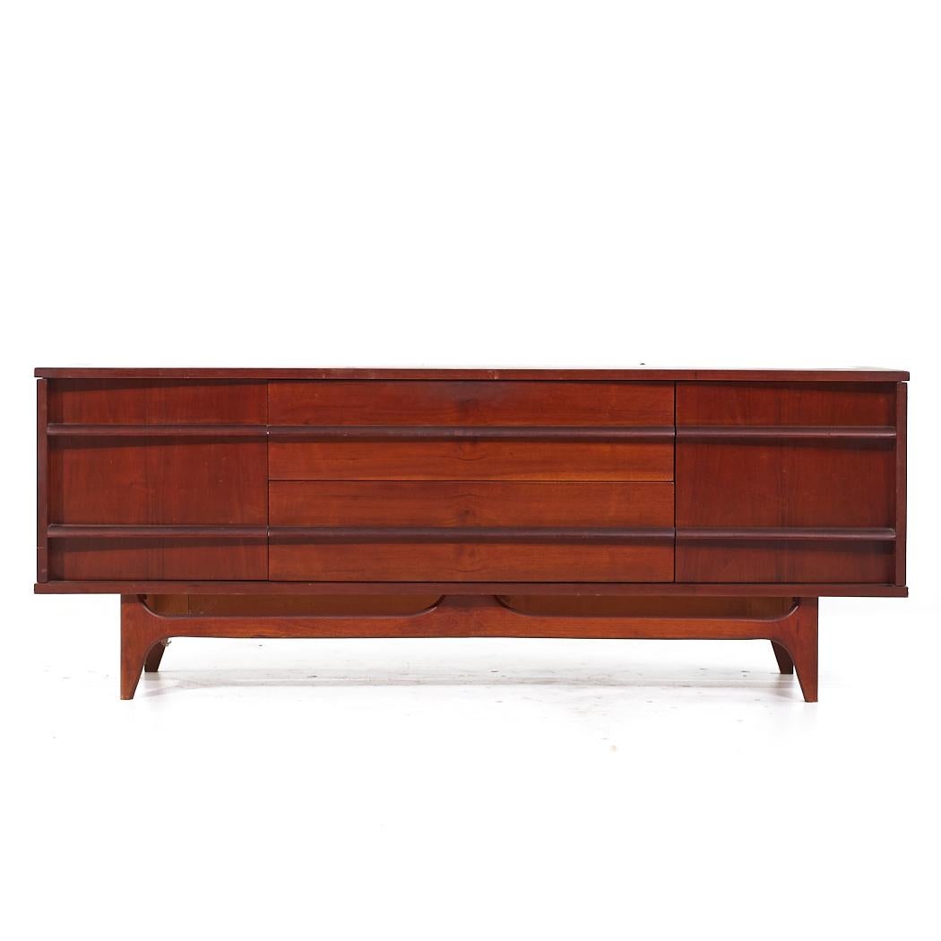 Young Manufacturing Mid Century Walnut Curved Credenza

This credenza measures: 64 wide x 19 deep x 24.75 inches high

All pieces of furniture can be had in what we call restored vintage condition. That means the piece is restored upon purchase so