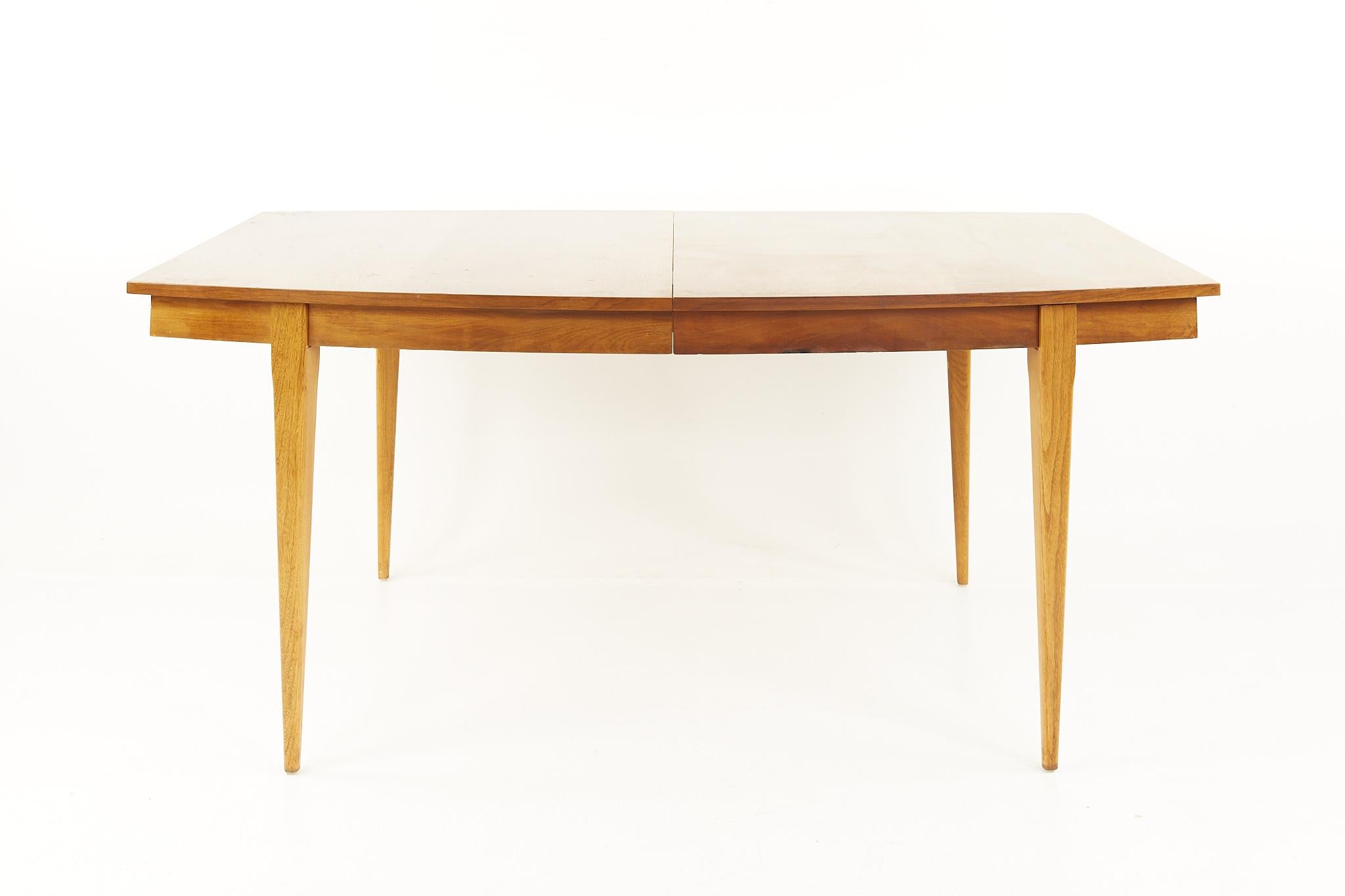 Young manufacturing mid century walnut dining table with 2 leaves

The table measures: 66 wide x 34 deep x 29.25 inches high, with a chair clearance of 25.75 inches high; each of the 2 leaves are 18 inches wide, making a maximum table width of 102
