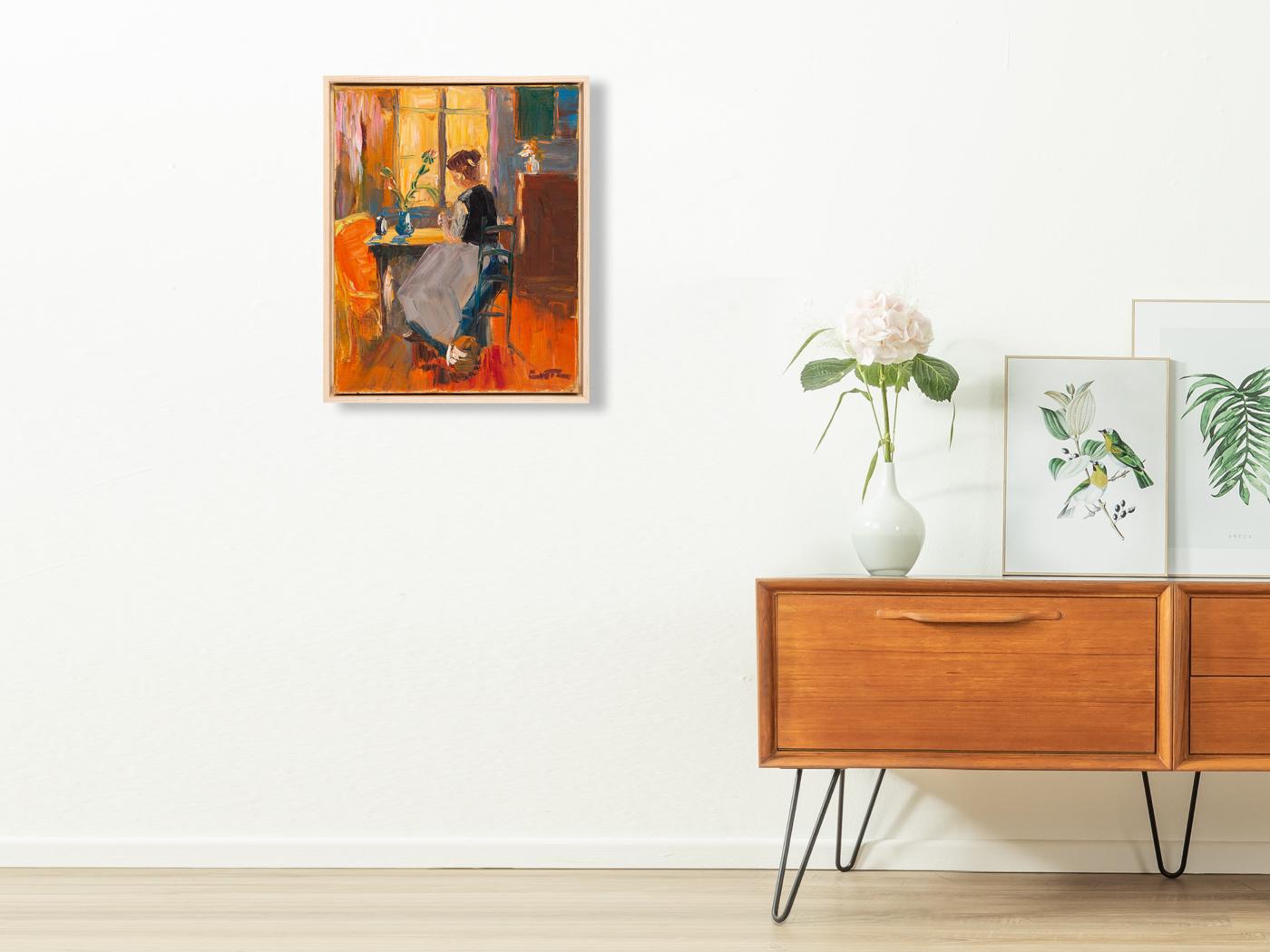 Light-flooded portrait of a young woman, sitting at a kitchen table with the morning sun in the background. Oil on canvas in an impressionist style, framed in a floater frame made of ashwood. Ready to hang.