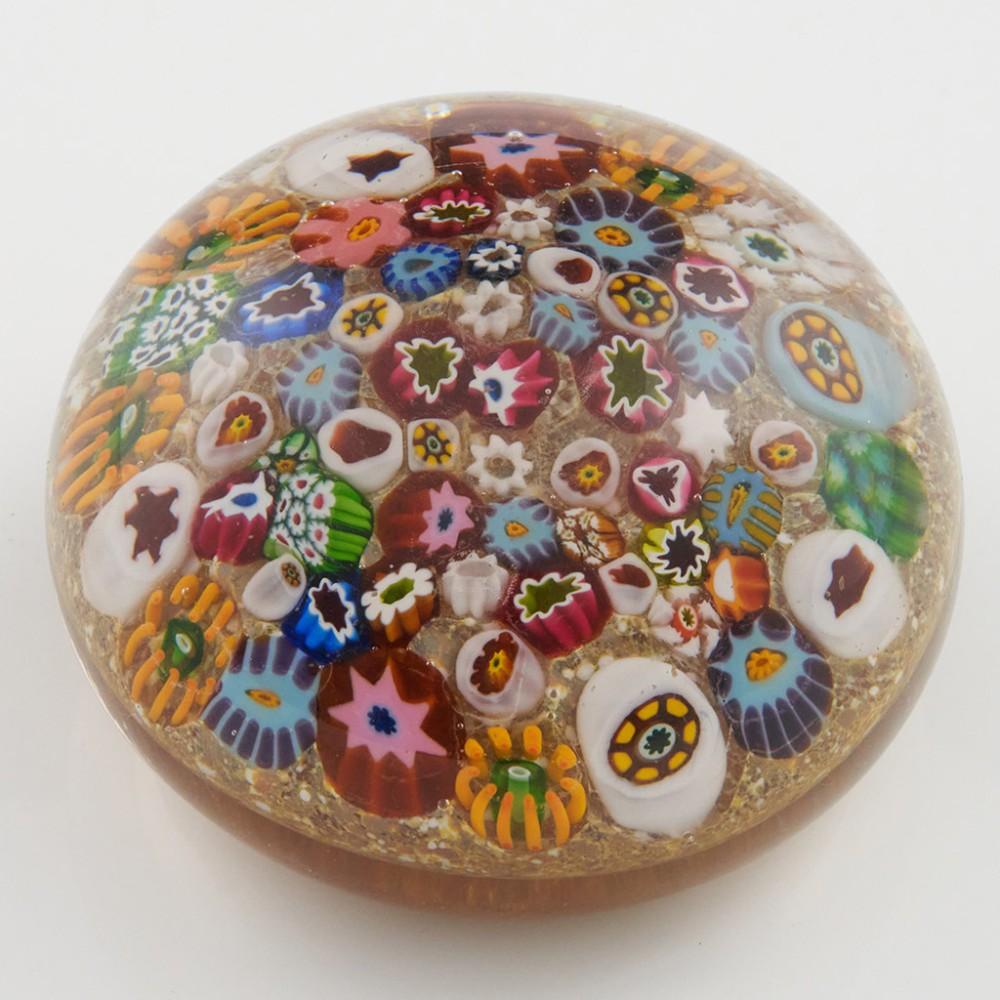 Heading : An Ysart Scramble Millefiori Magnum Paperweight c1950
Date : c1950
Origin :Scotland
Features : multiple polychrome millefiori canes scattered on a gold ground
Marks : None
Type : Lead
Size : 8.7cm diameter, 5.5cm height
Condition :