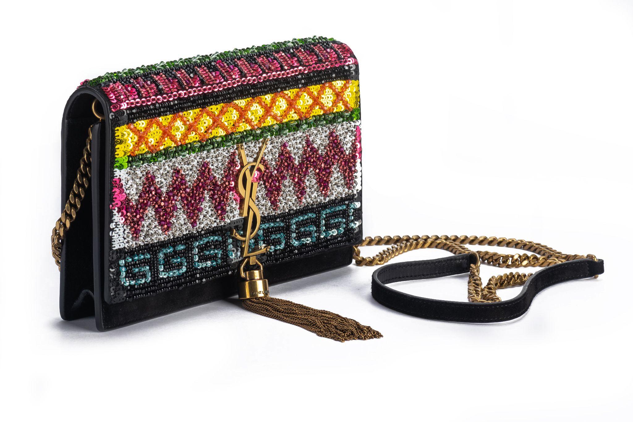 Nuevo bolso cruzado de ante negro de la marca YSL con pedrería de lentejuelas multicolor, borla en tono dorado . Caída del hombro 23. Precio original 2980 $. Viene con la funda guardapolvo original.