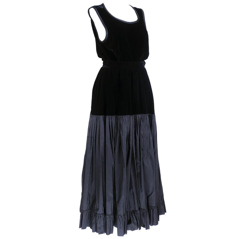 Klassisches und elegantes Ensemble des Meisters Yves Saint Laurent aus den 1980er Jahren. Schlichter Panzer aus Samt mit Satinbesatz. Passend dazu der volle Rock aus Samt und Taft in Stufen.

Zusätzliche Informationen: 
Top
Büste: 38