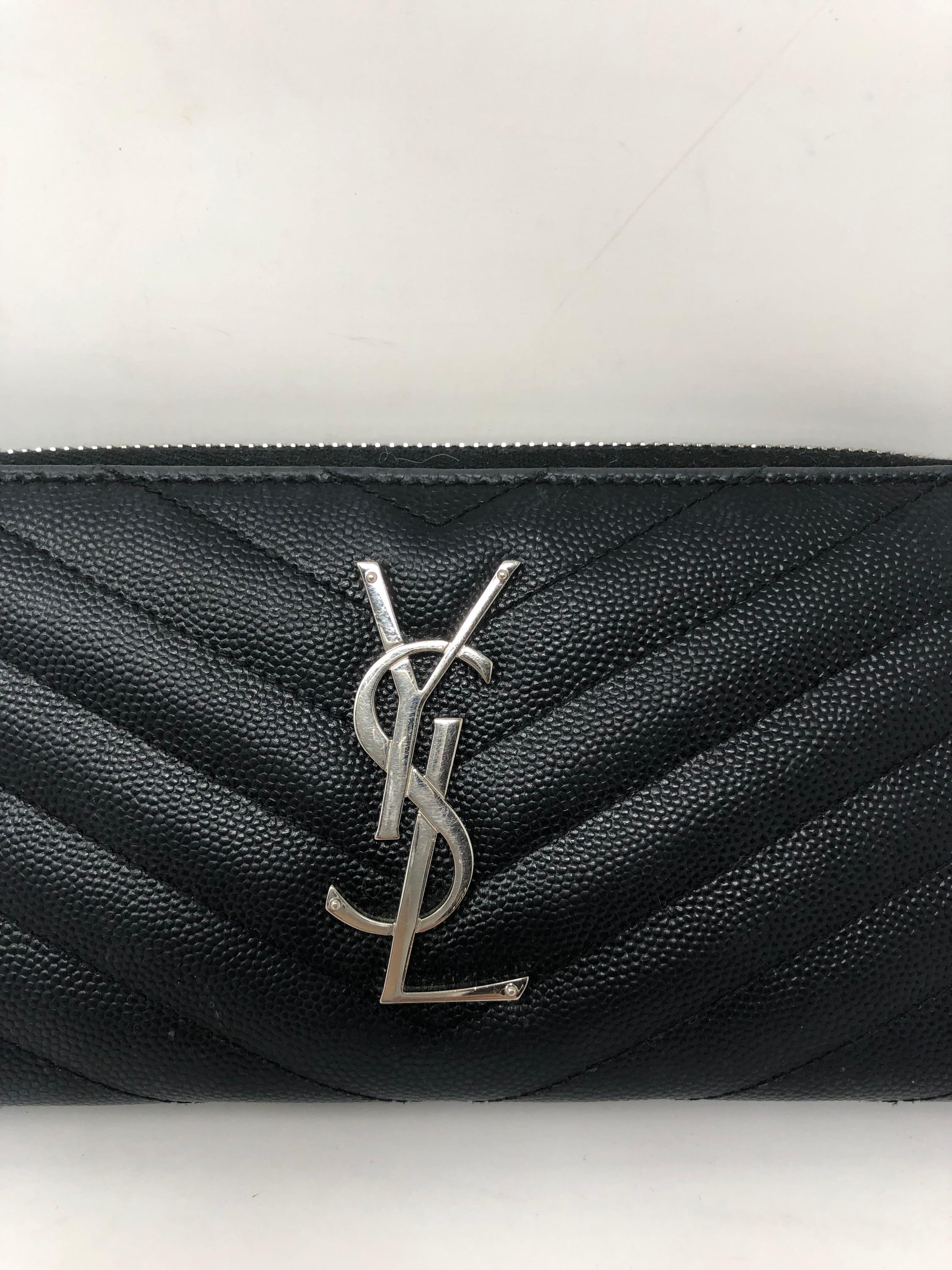 YSL Black Leather Wallet. Silver hardware. Caviar leather zippy wallet. Mint like new condition. Can be worn as a clutch too. Guaranteed authentic. 