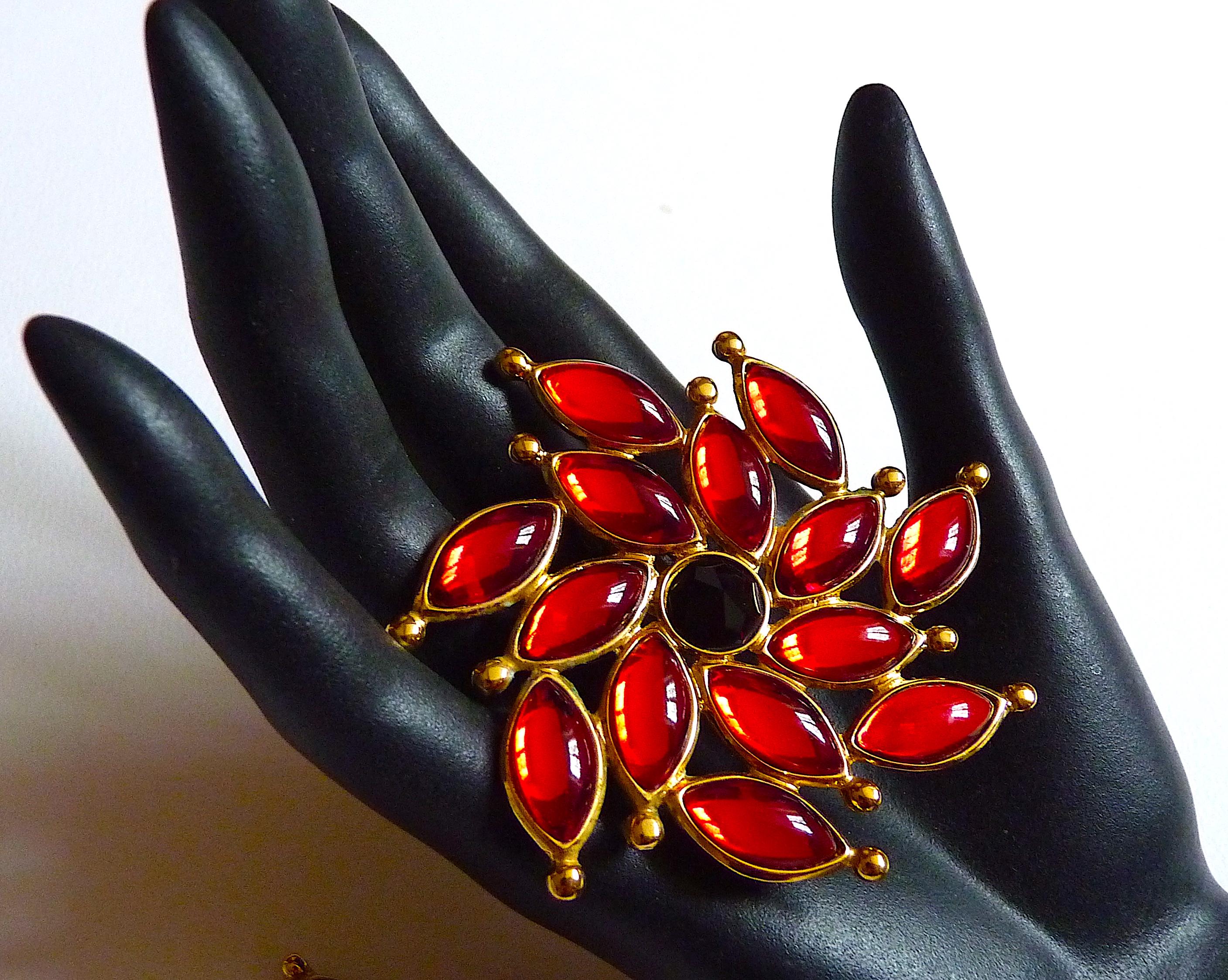YSL PARIS by Robert Goossens Oversized Red Flower Clip On Earrings adorned with black Central and Red Cabochons on Gold Tone Metal, Vintage from the 1980s. 

Stamped YSL at back of each clip, and Made in France at back of one clip

CONDITION : Very