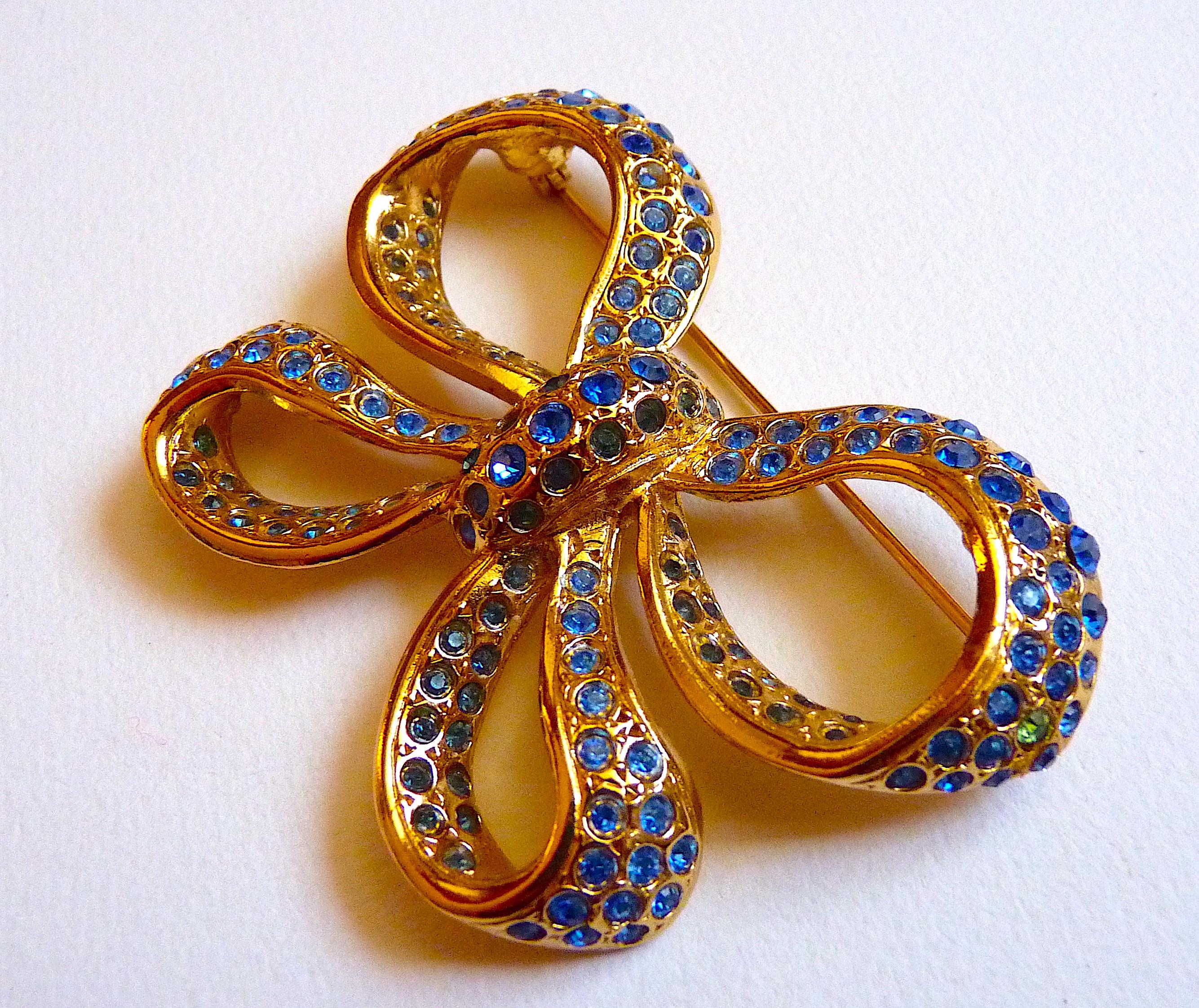 this is a rare iconic vintage YSL Yves Saint Laurent Bow Brooch, gold Tone Metal adorned with Blue Crystal Stones.

Vintage from the 1980s

Signed YSL Made in France at Back

Condition : Very nice vintage condition, one blue stone is slightly