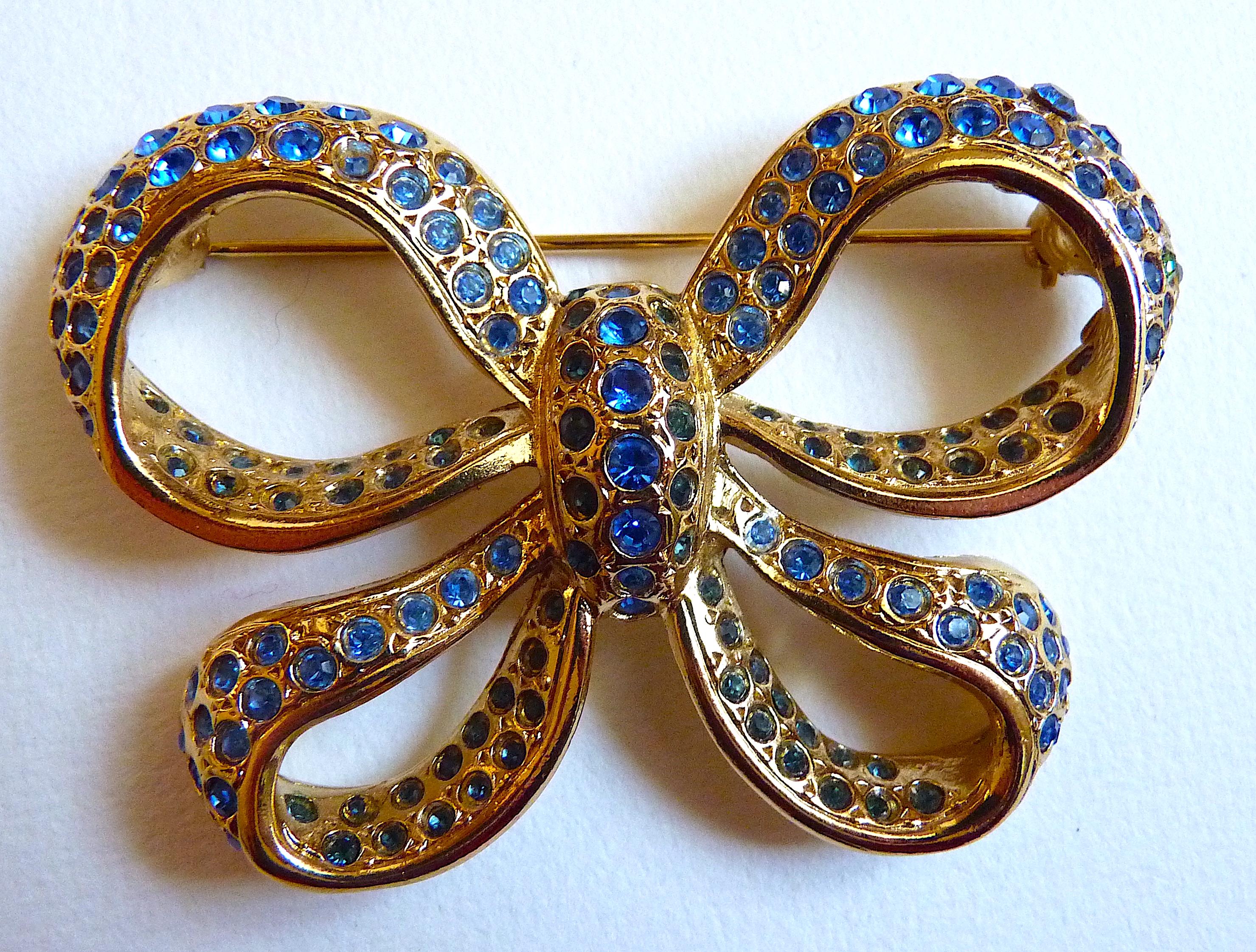YSL Bogenbrosche aus vergoldetem Metall und blauen Kristallsteinen, Vintage 1980er Jahre im Angebot 1