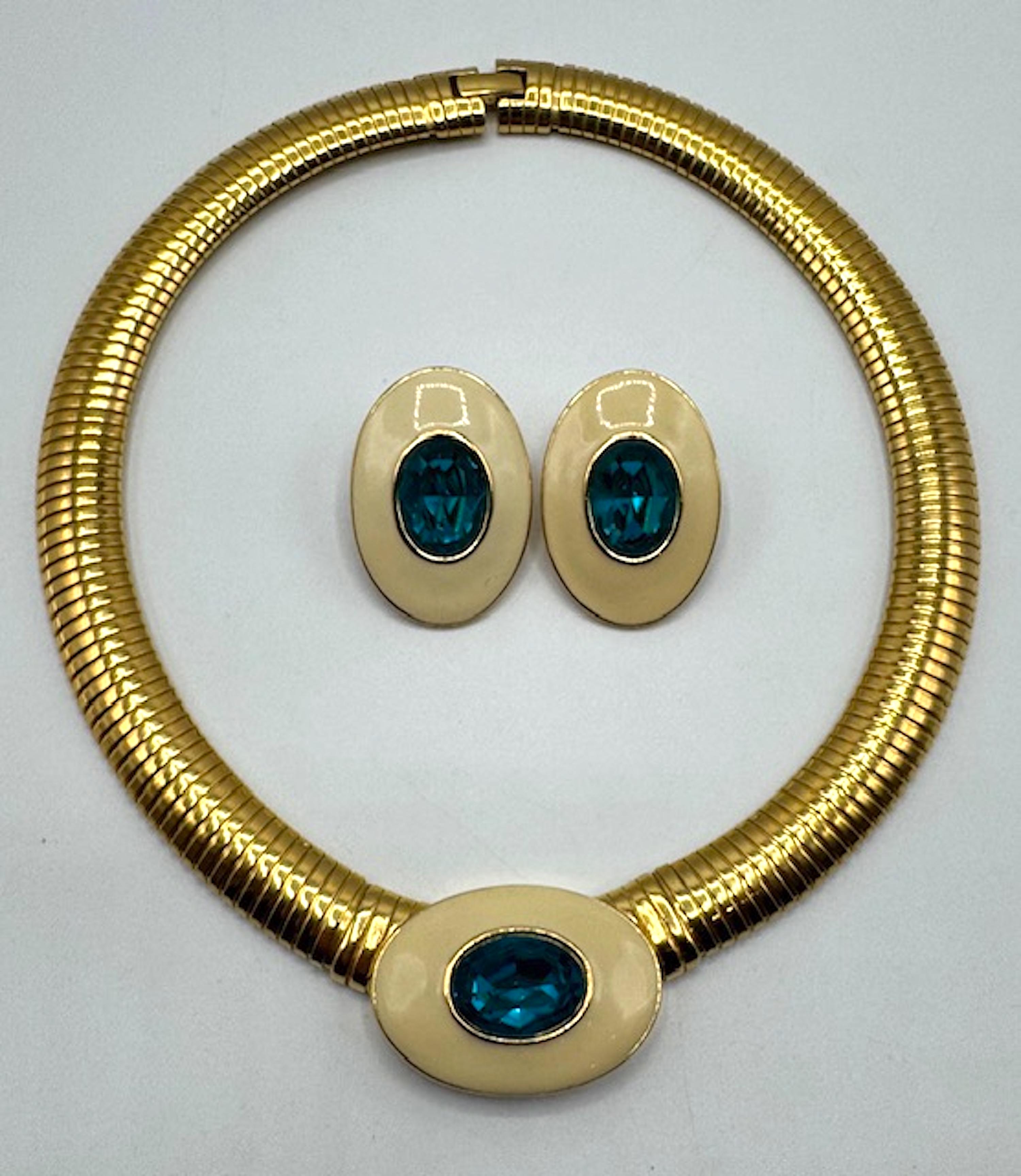 Voici un ensemble de bijoux Yves Saint Laurent des années 1980 comprenant un collier ras de cou en métal doré à maillons oméga de 16 pouces et des boucles d'oreilles assorties. Le lien oméga a une largeur de 0,5'. Le centre du collier comporte un