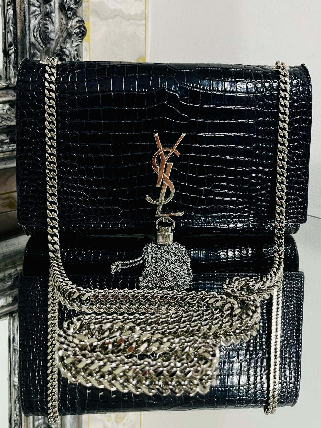 YSL Kate Bag In Crocodile Embossed Leather

Black shiny leather that is embossed in a Crocodile skin finish

and silver hardware. Front 'YSL' logo and a long multi chain 

tassel to the front. Rrp £2090.

Size - Medium Model - Height 16cm, Width