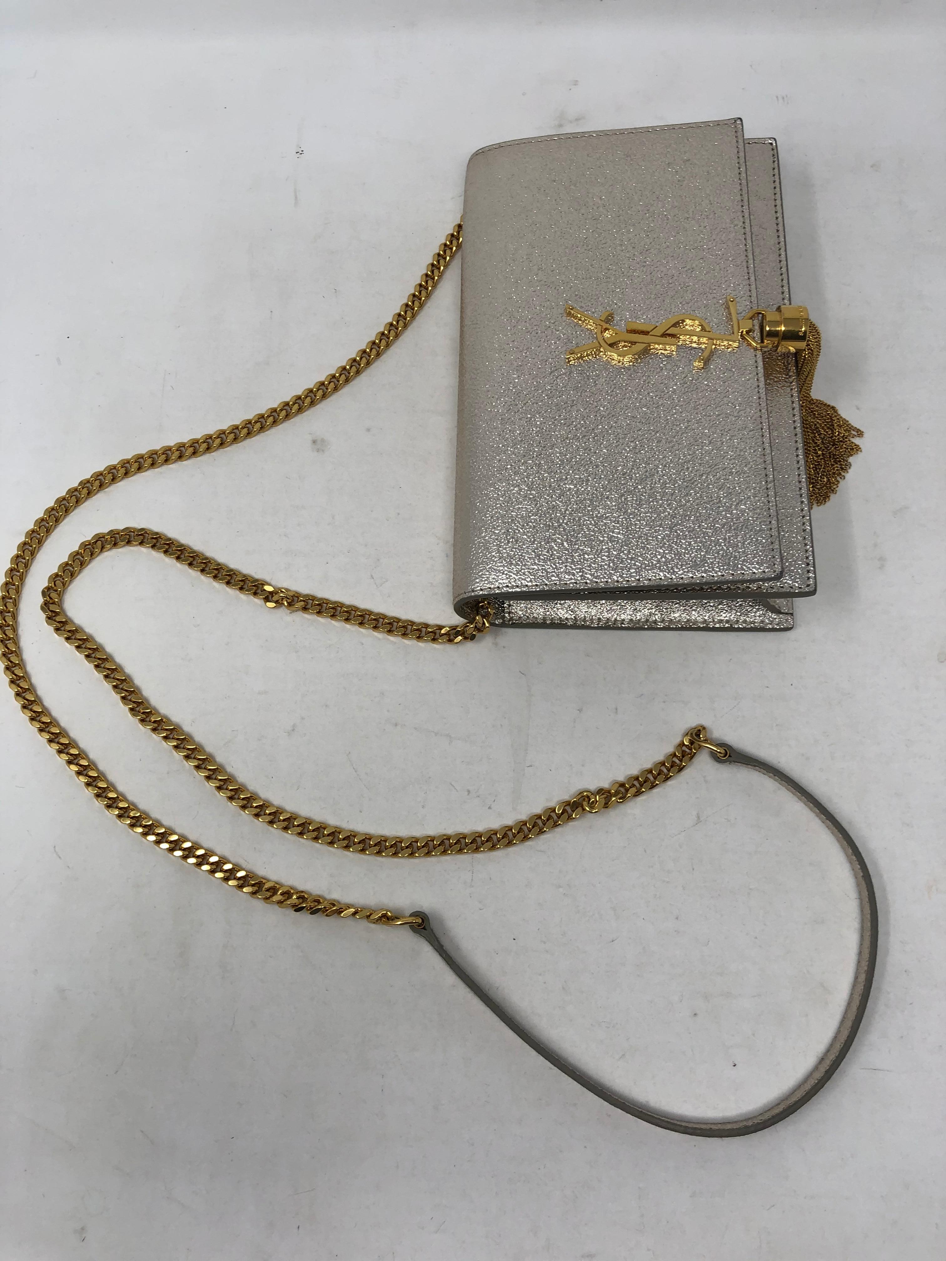 Yves Saint Laurent Kate Metallic Silver and Gold Bag. Can be worn as a crossbody or a clutch. Beautiful silver metallic leather and gold YSL with tassel. Excellent condition. Includes YSL dust cover. Guaranteed authentic. 