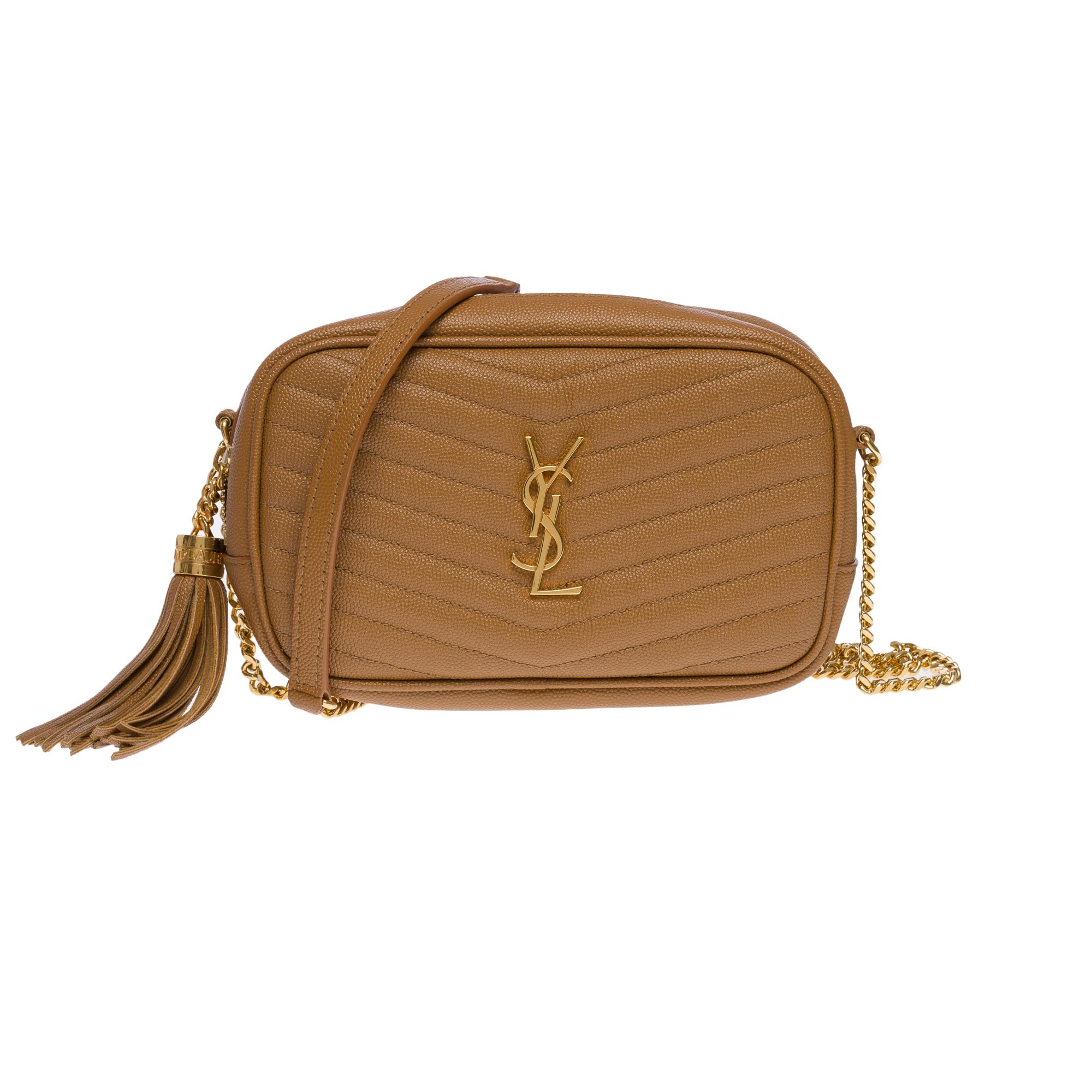 The Classy Saint Laurent Lou Camera shoulder bag in Camel calfskin leather stitched with the iconic quilted chevron decorated with the cassandra and a removable leather tassel. Gold metal hardware, gold metal chain handle for shoulder or crossbody