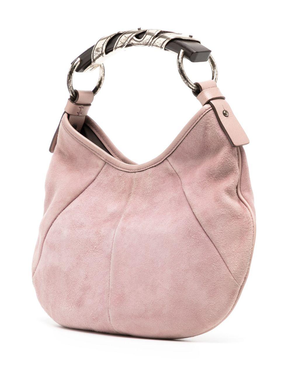 Chic Mini Mombasa suede top handle bag in blush pink.
Hobo silhouette crafted from panels of triangular suede leather, completed with a unique metal and wood horn-shaped handle detail. 
Magnetic fastening.
Silver-tone hardware.
This bag is in good