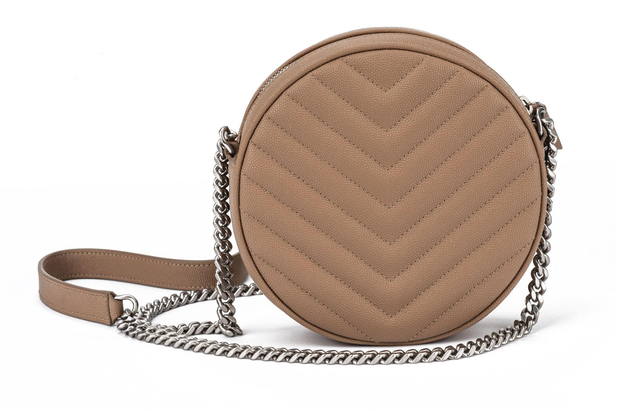 YSL brand new beige caviar round camera bag with silver tone hardware. Exterior signature YSL logo in the center. Zip around top closure .
Cross body shoulder strap measures 21