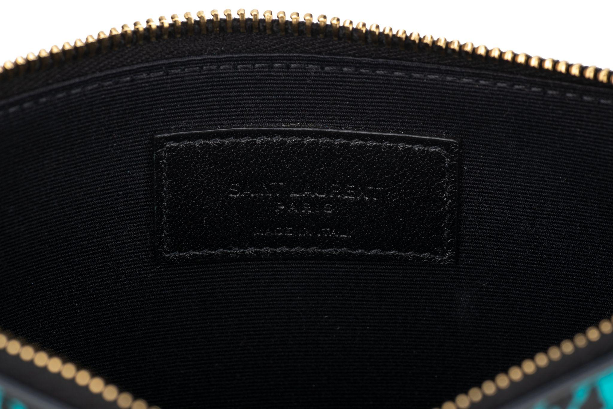 Yves Saint Laurent pouch made of smooth calfskin leather in a leopard/heart pattern. Saint Laurent Paris logo printed is printed in gold. Gold top zipper opens to a black fabric interior. The piece is new and comes with the booklet, dustcover and