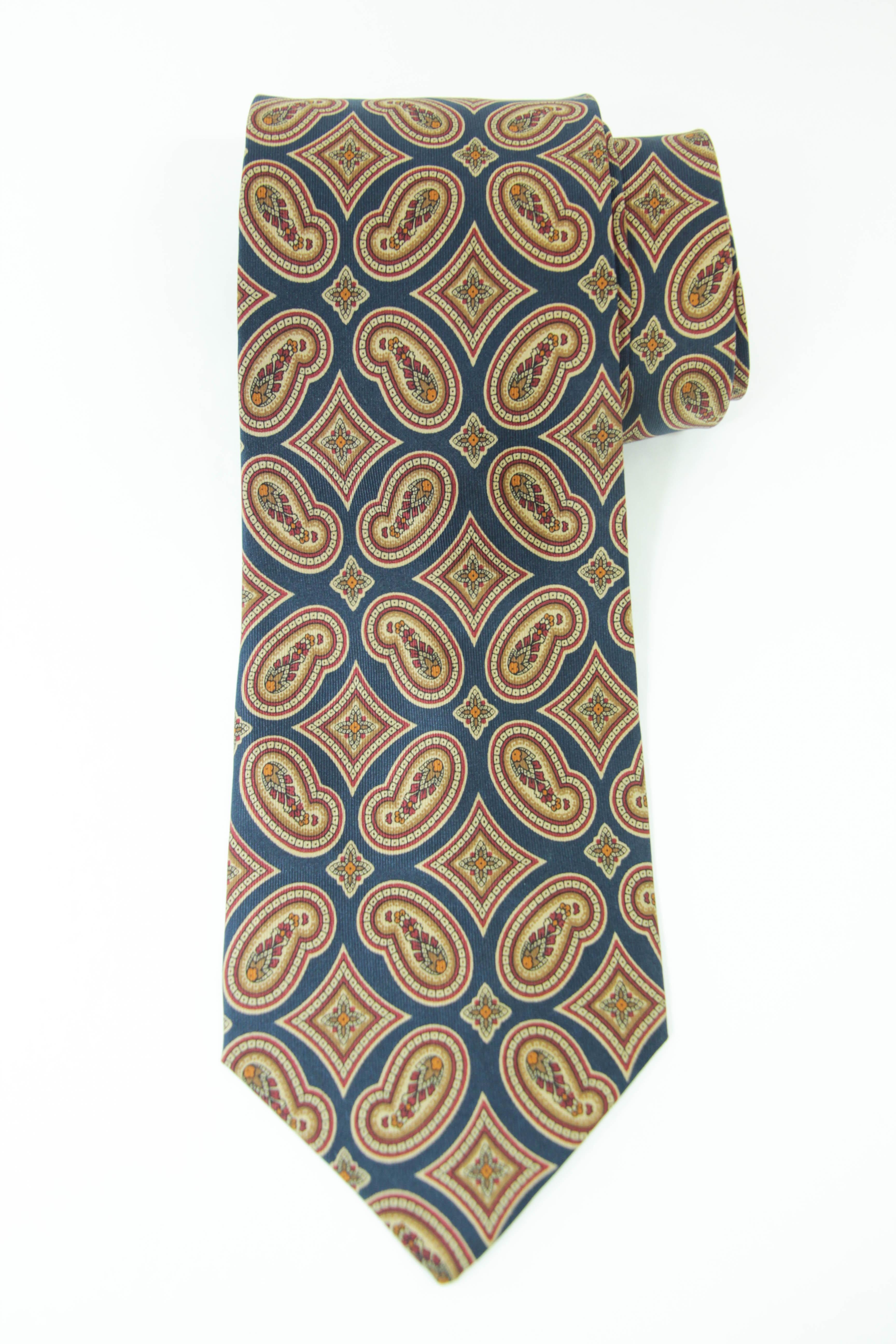 Vintage YSL Paris Yves Saint Laurent necktie mens silk paisley abstract geometric design.
Authentic, preowned, vintage Yves Saint Laurent necktie, most likely made in the 1980s. 
Blue with paisley geometric gold pattern design.
From the iconic