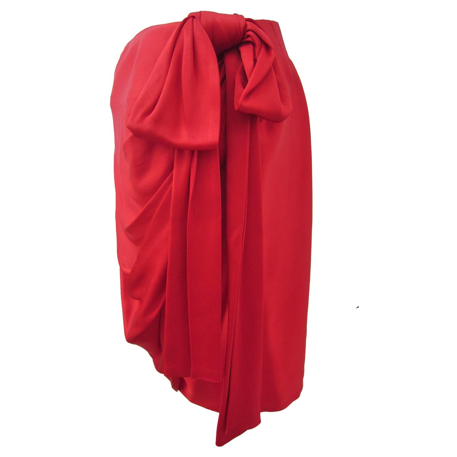 YSL Rive Gauche incredible red skirt from circa 1985.
The draped skirt fastens wrap style across the front with oversized bow. A push button and hooks closure. 
Original size : 40 FR, Fits a US 6 
