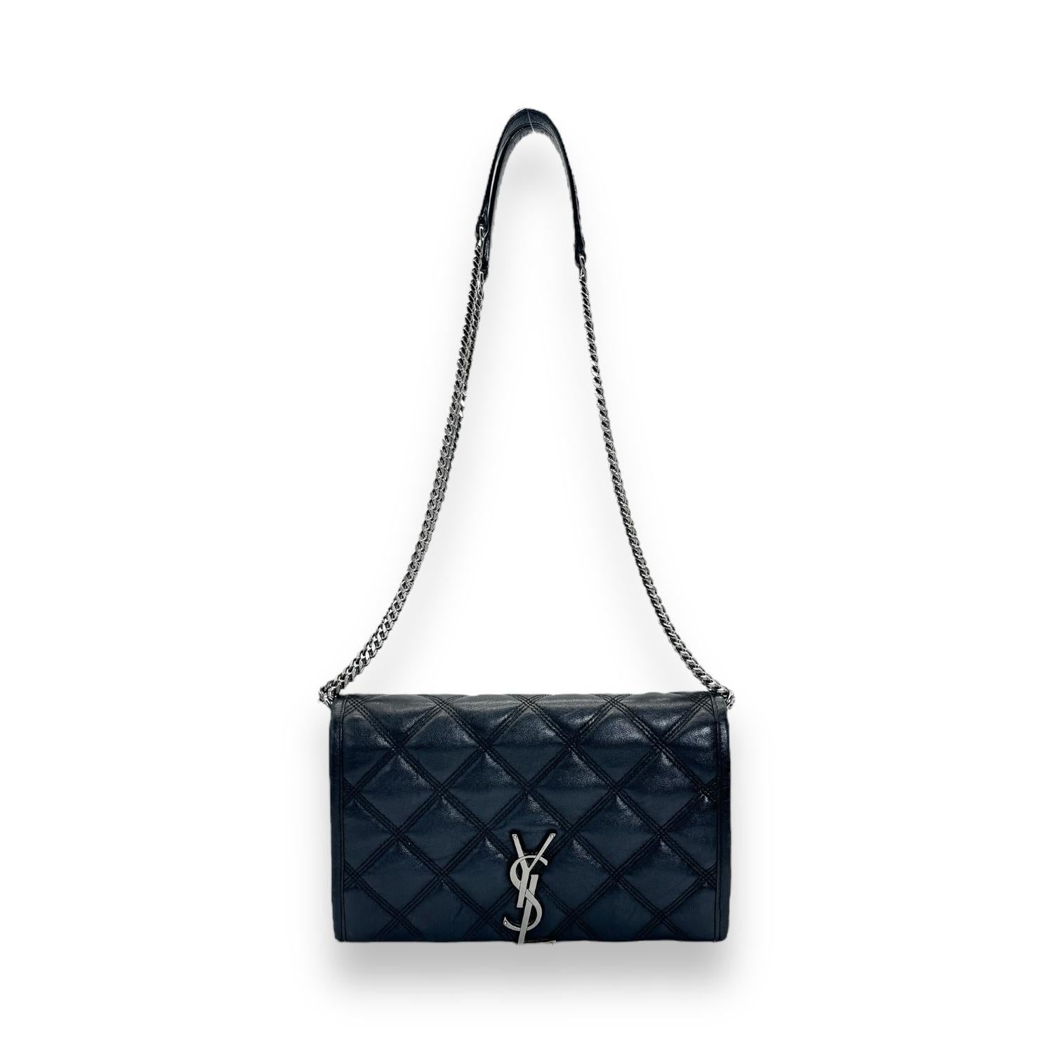 Saint Laurent YSL Saint Laurent Becky Quilted Wallet on Chain in black. The bag features polished silver-tone hardware, chain shoulder straps and a YSL emblem on the front flap. The flap opens to a black leather interior with zipper and patch