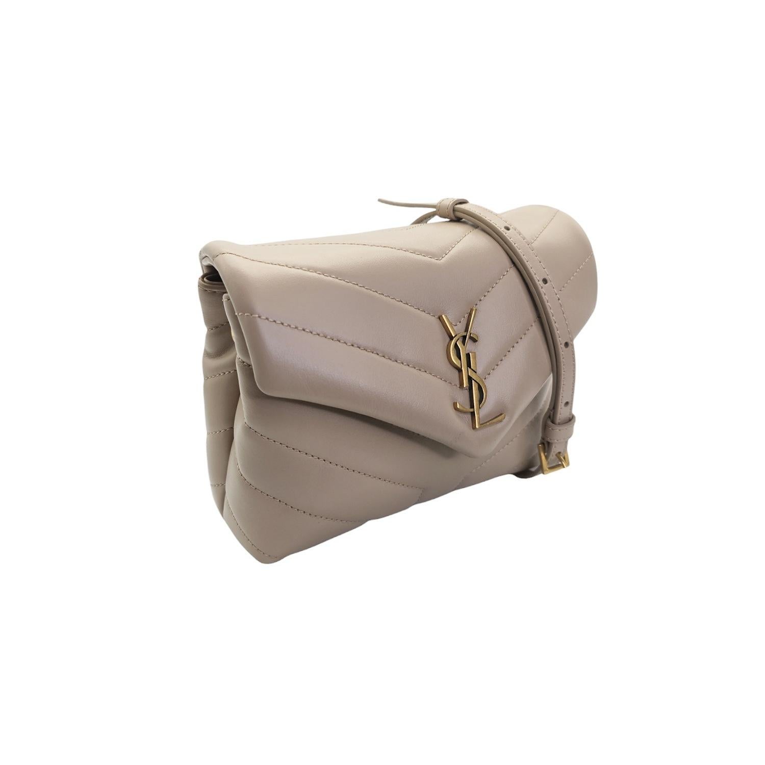 Indulge in luxury with the YSL Saint Laurent Dark Beige Toy Loulou Crossbody. Its compact size and adjustable leather strap offer practicality while the iconic chevron quilting and bronze-toned hardware exude sophistication. Featuring two
