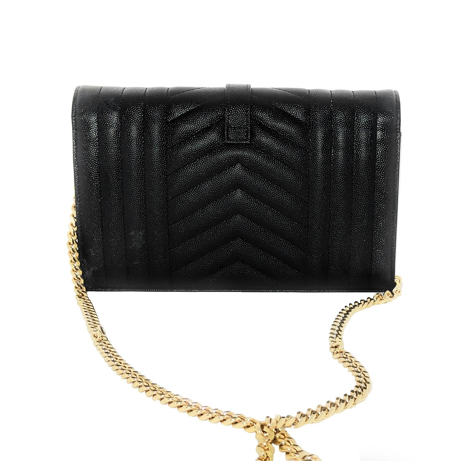 This elegant wallet on a chain is crafted of finely pebbled chevron quilted leather in black. The shoulder bag features a removable waist-length bijoux gold chain shoulder strap with a shoulder pad and a gold classic YSL emblem on the flap. This