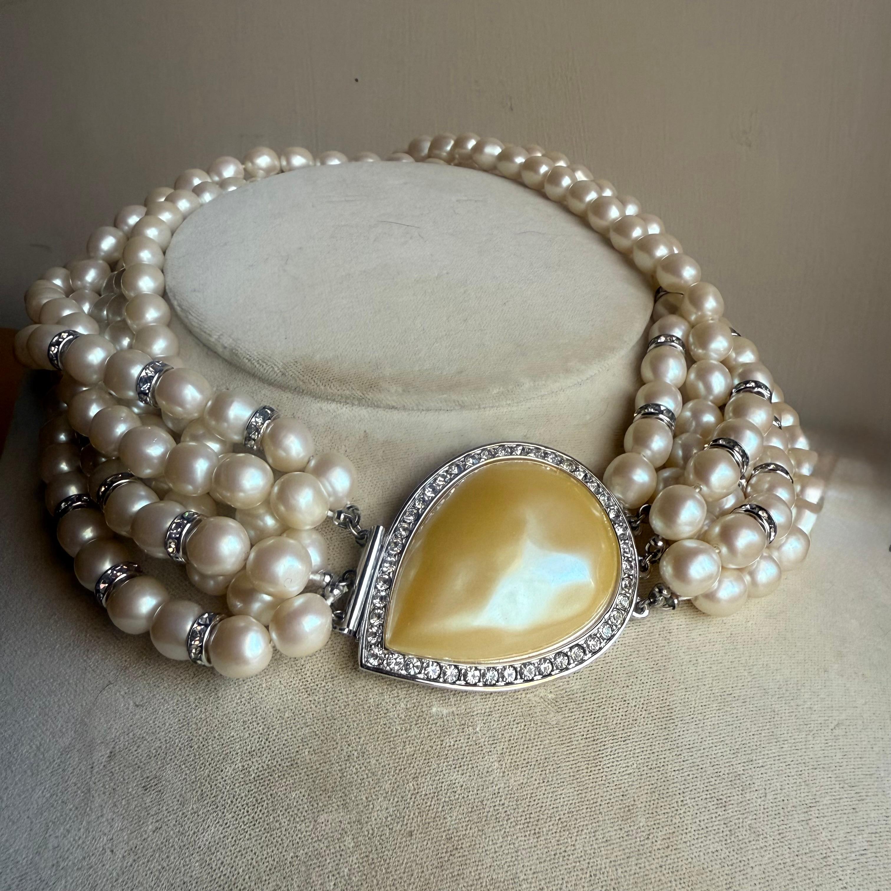 Un colletto di perle finte particolarmente impressionante della Maison Yves Saint Laurent. Sei file di opulente e morbide perle finte color crema, modellate organicamente e intervallate da rondelle con cristalli incastonati. Una perla finta di