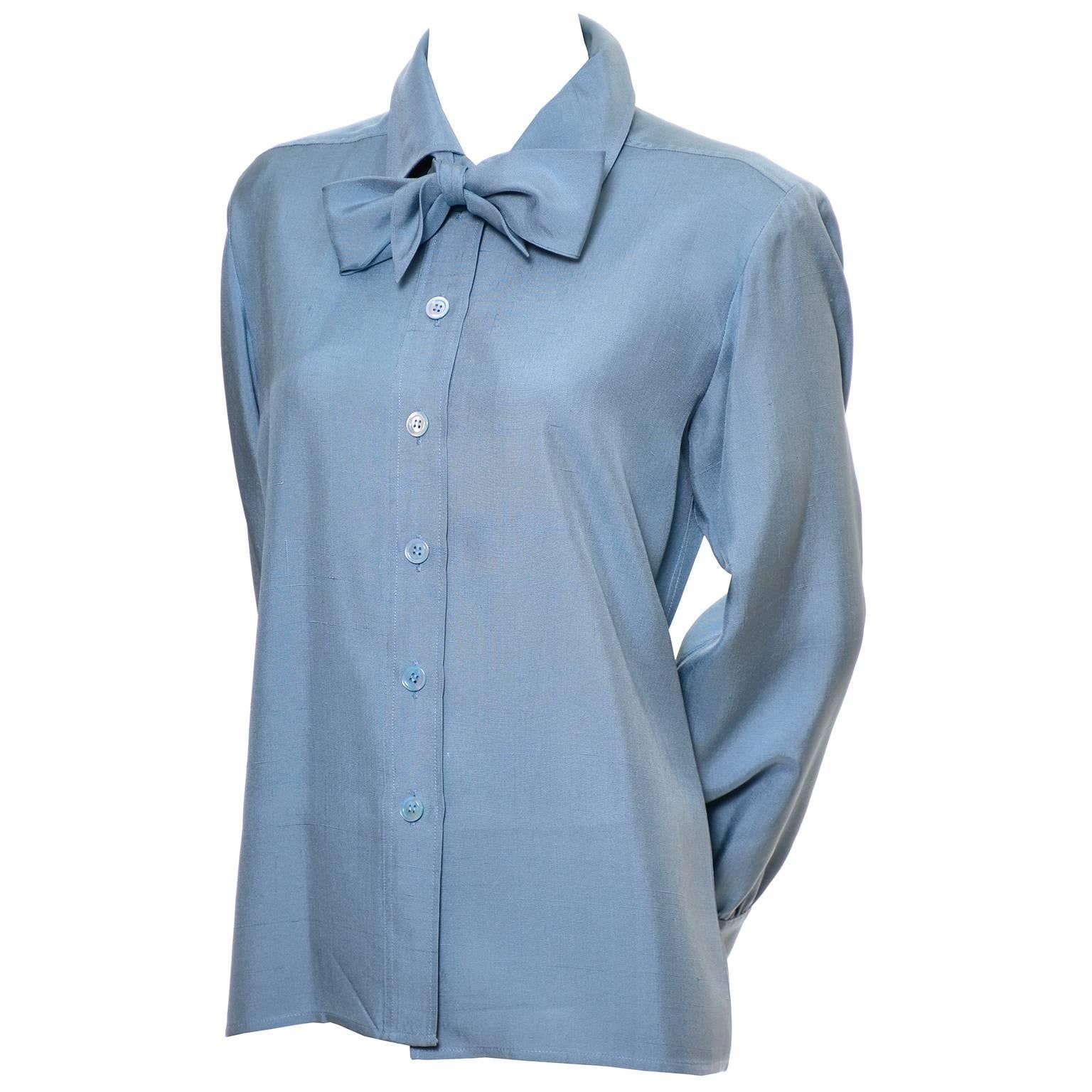 This lovely vintage blue silk long sleeve blouse was designed by Yves Saint Laurent in the late 1970's. This raw silk button front blouse has a fabric tie at the neck that can be tied into a knot or a bow.  The blouse is labeled a French size 38 and