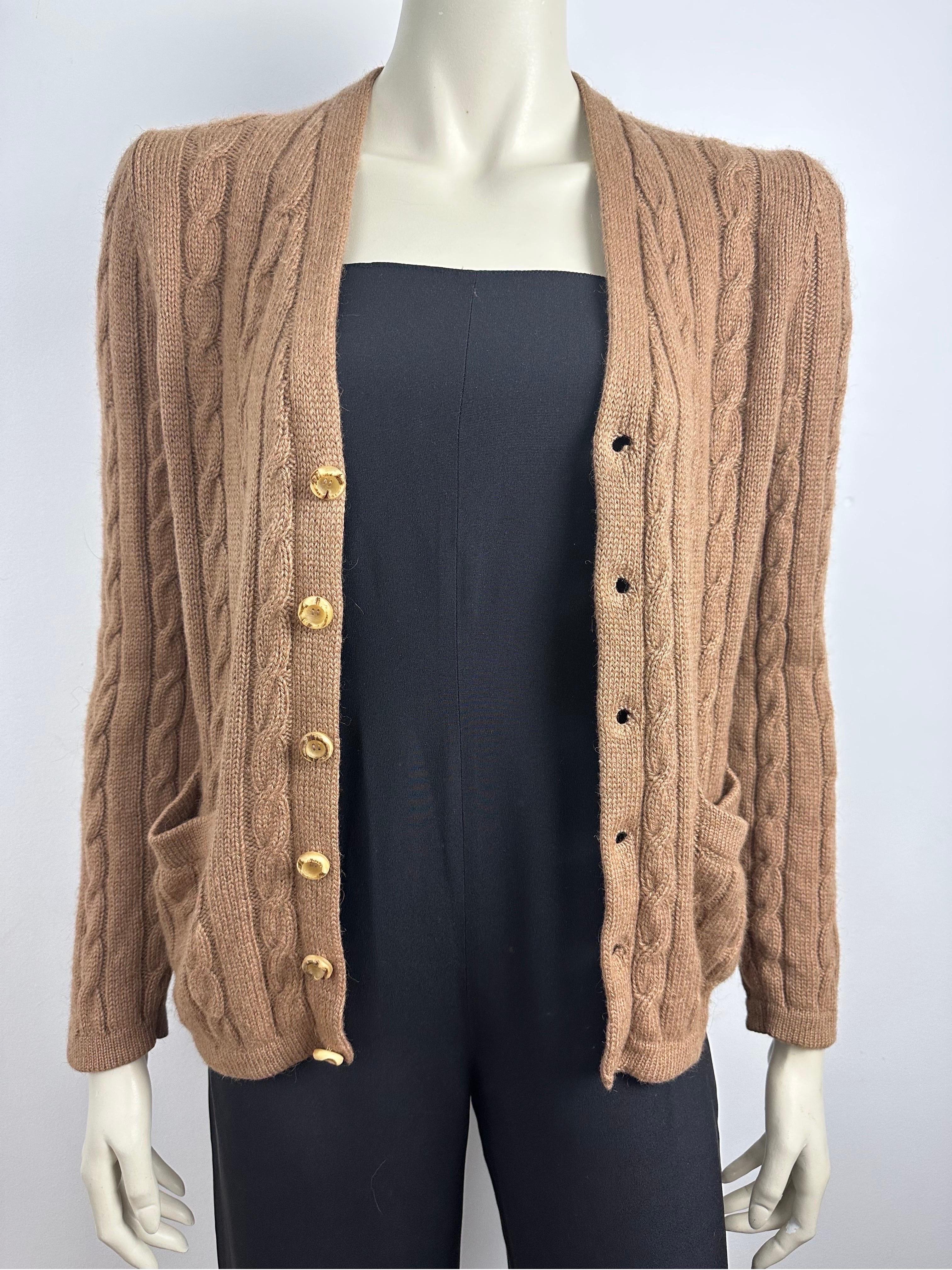 Vintage 1970s Yves saint Laurent cardigan
In camel wool
Twisted, long sleeves, V-neckline, natural horn buttons.
Small open pockets on bottom of cardigan
Made in Italy
Size 2, 
shoulders 40cm
Chest width 46cm
Length 60cm, sleeves 60cm
In very good