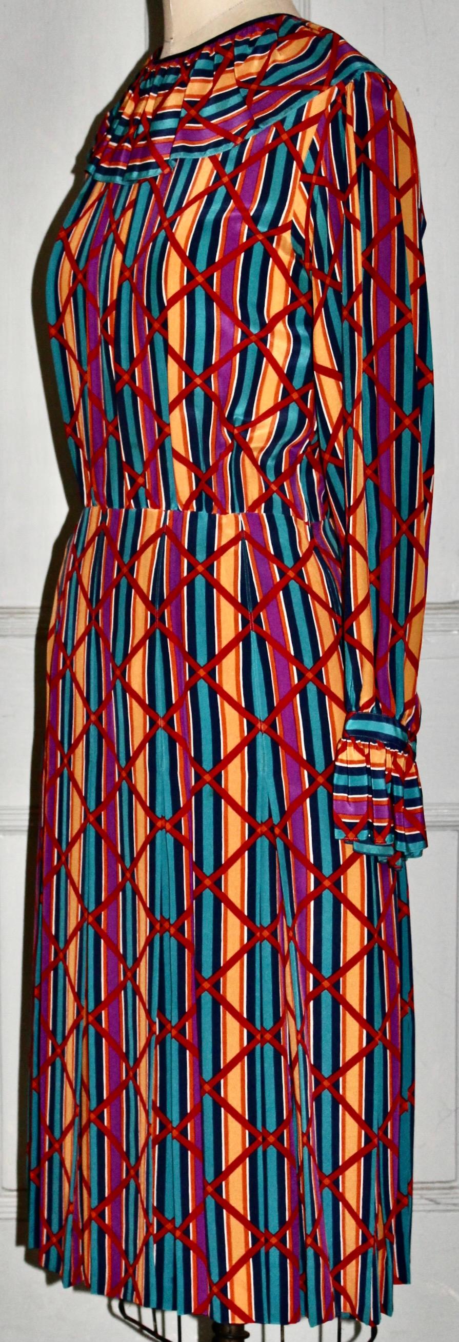 Offering a very colorful abstract patterned silk day dress Designed by Yves Saint Laurent Rive Gauche (Labeled). Size Eu 40. With a button on back at the collar. Waist to hem 26.5