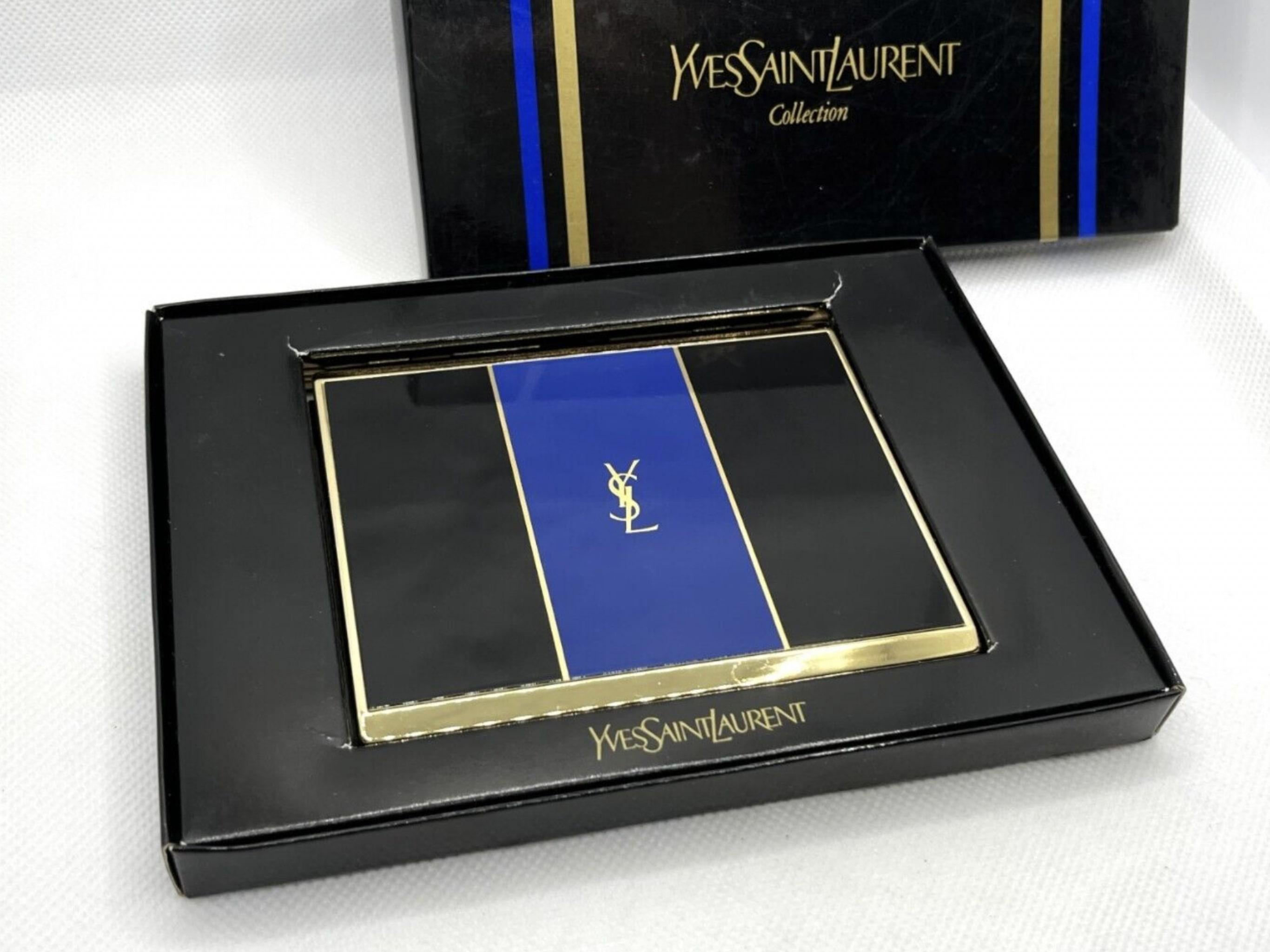 “YSL” Yves Saint Laurent retro cigarette case 
Logo Cigarette Case Gold Black Blue
The case is in mint condition. Was never use. In original Yves Saint Laurent box. 
The clasp snaps as new. 
Retro. 
Circa 1980s
Gold plated. 
Signed YSL.
Very elegant
