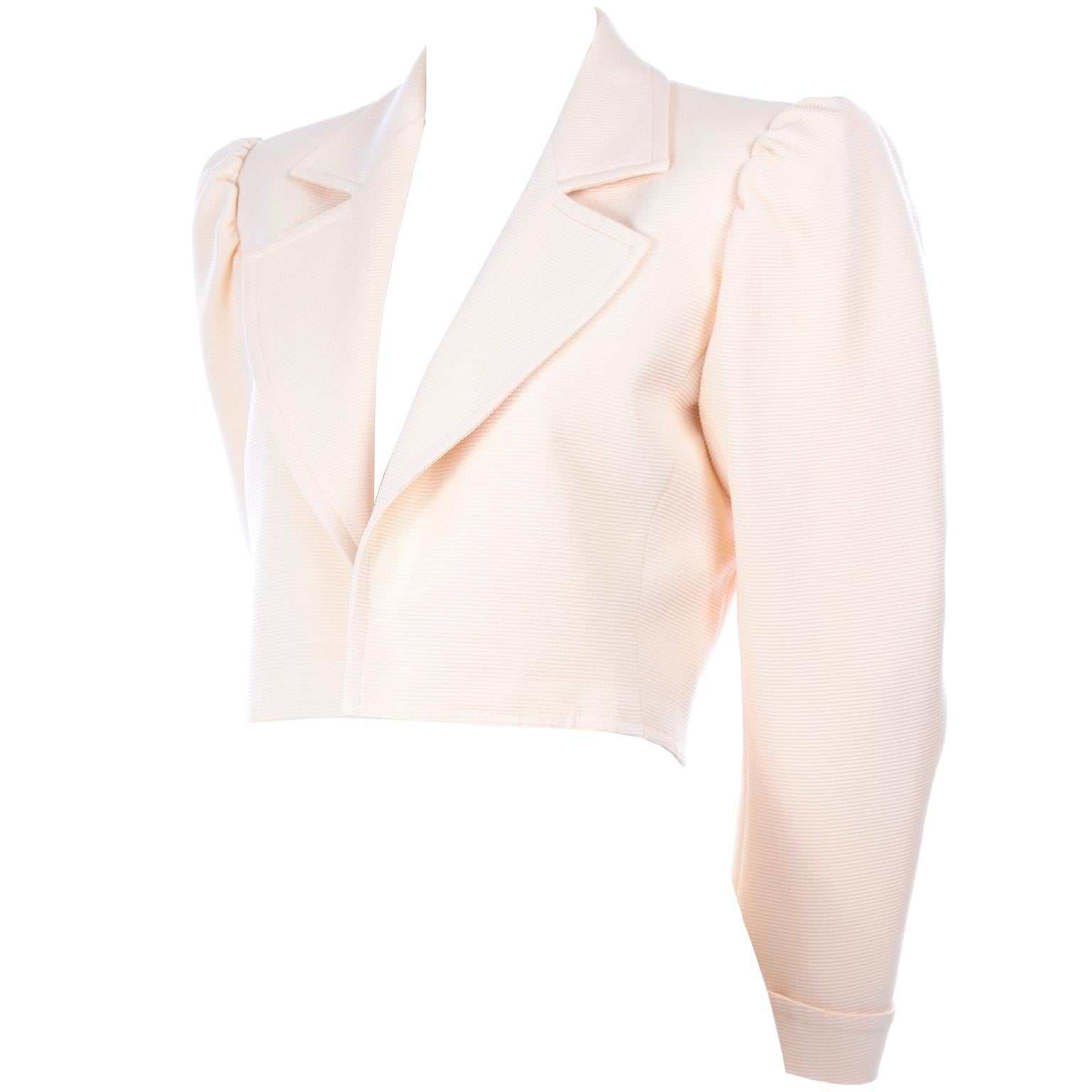 This is a versatile Yves Saint Laurent vintage cropped jacket with and open front. It made in a ribbed cream fabric with a cream silk lining. This is a great YSL blazer that can be worn today effortlessly with its gathered shoulders and cuffed
