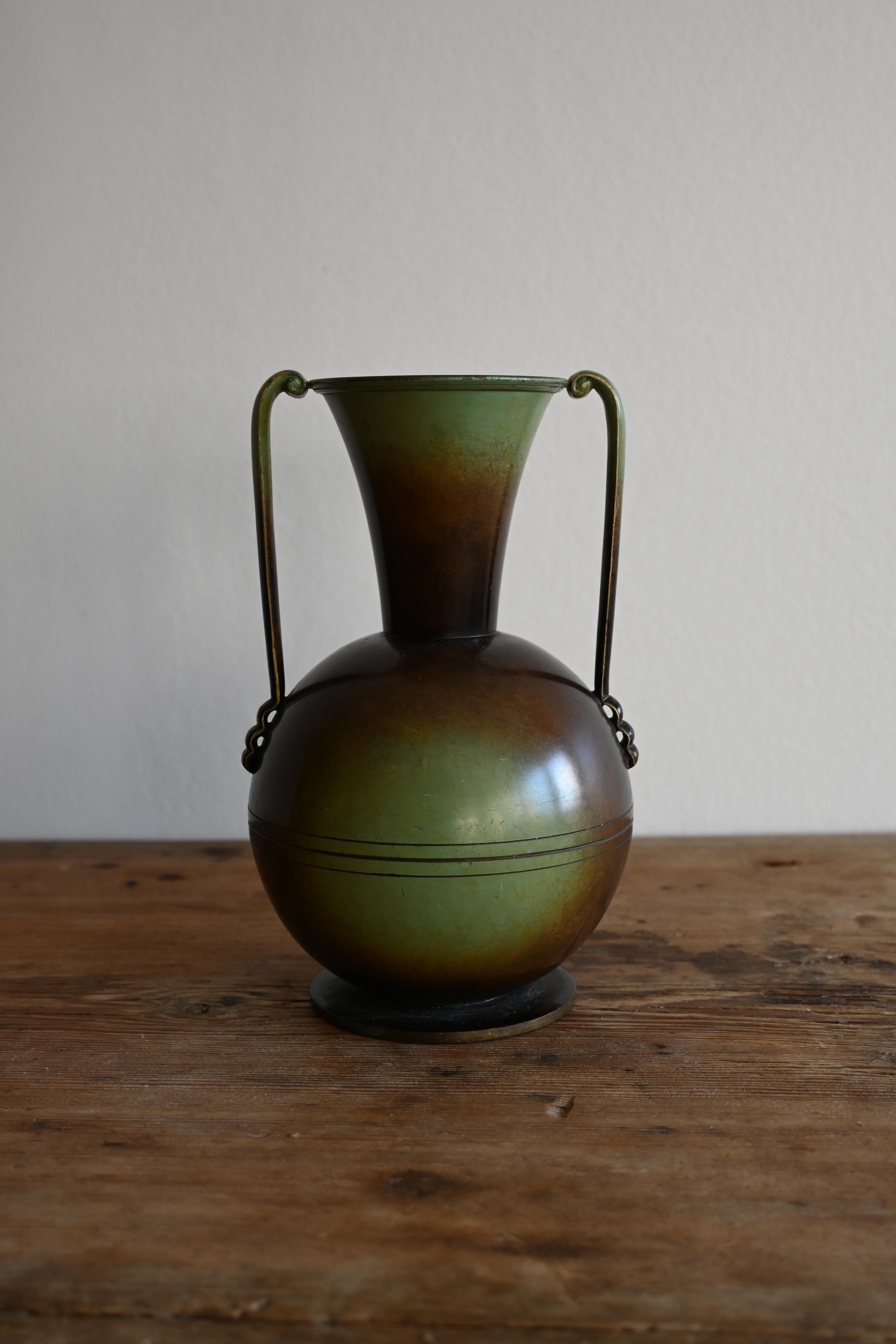 Magnifique vase en bronze patiné d'Ystad Brons, Suède, datant des années 1940. 

Elegant vase en bronze patiné avec des poignées marquées 