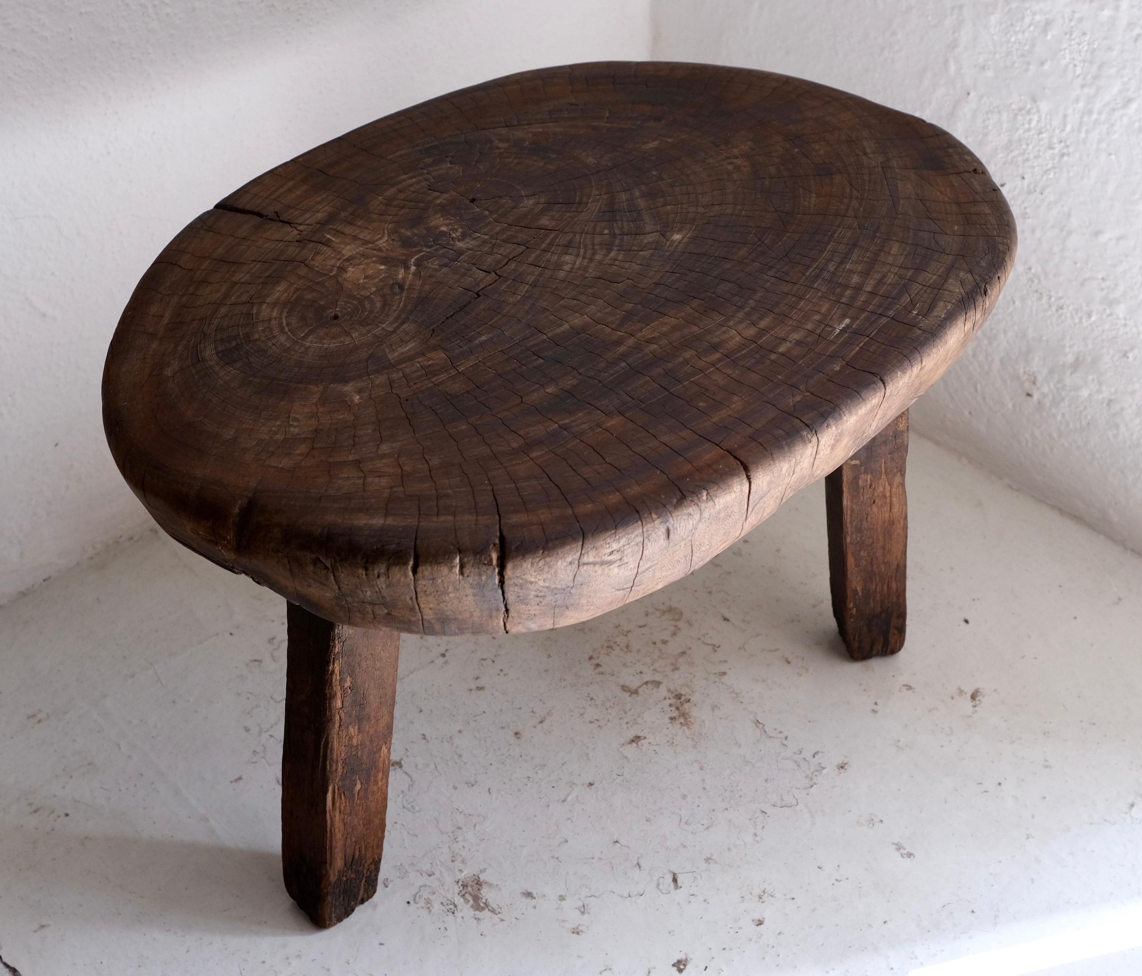 Rustic side table from the Yucatan Peninsula, circa 1970's. Sourced in the southern area of Yucatan, these tables are solid and extremely sturdy. The three legs have been secured and stabilized. The table top is an end cut piece which is somewhat