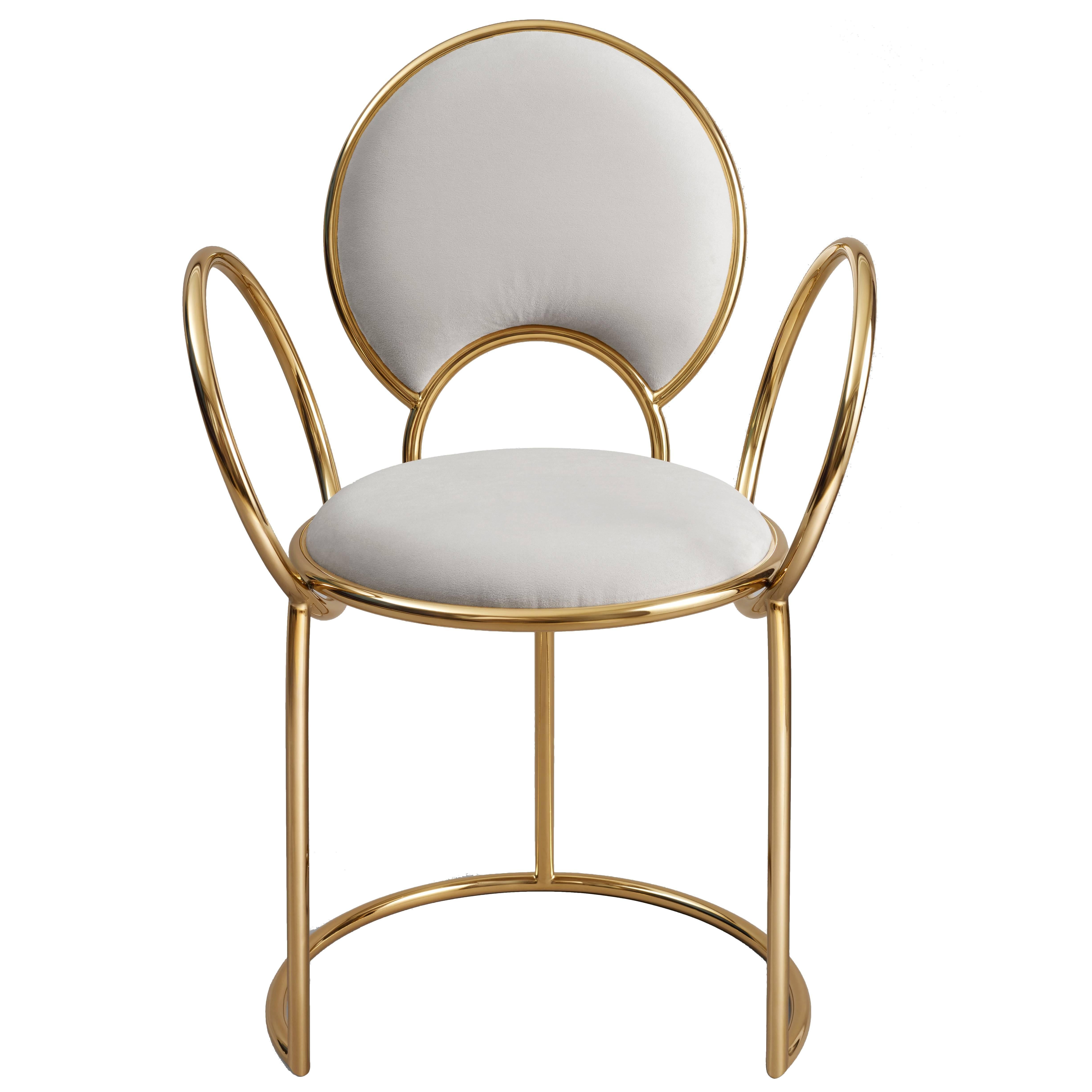 The 'Yue chair' by much acclaimed duo Studio MVW is produced in anodized stainless steel with brass finish in a subtile gold pink shade. The delicate loop armrests completing the rounded light grey velvet covered seat and back make the chair a true