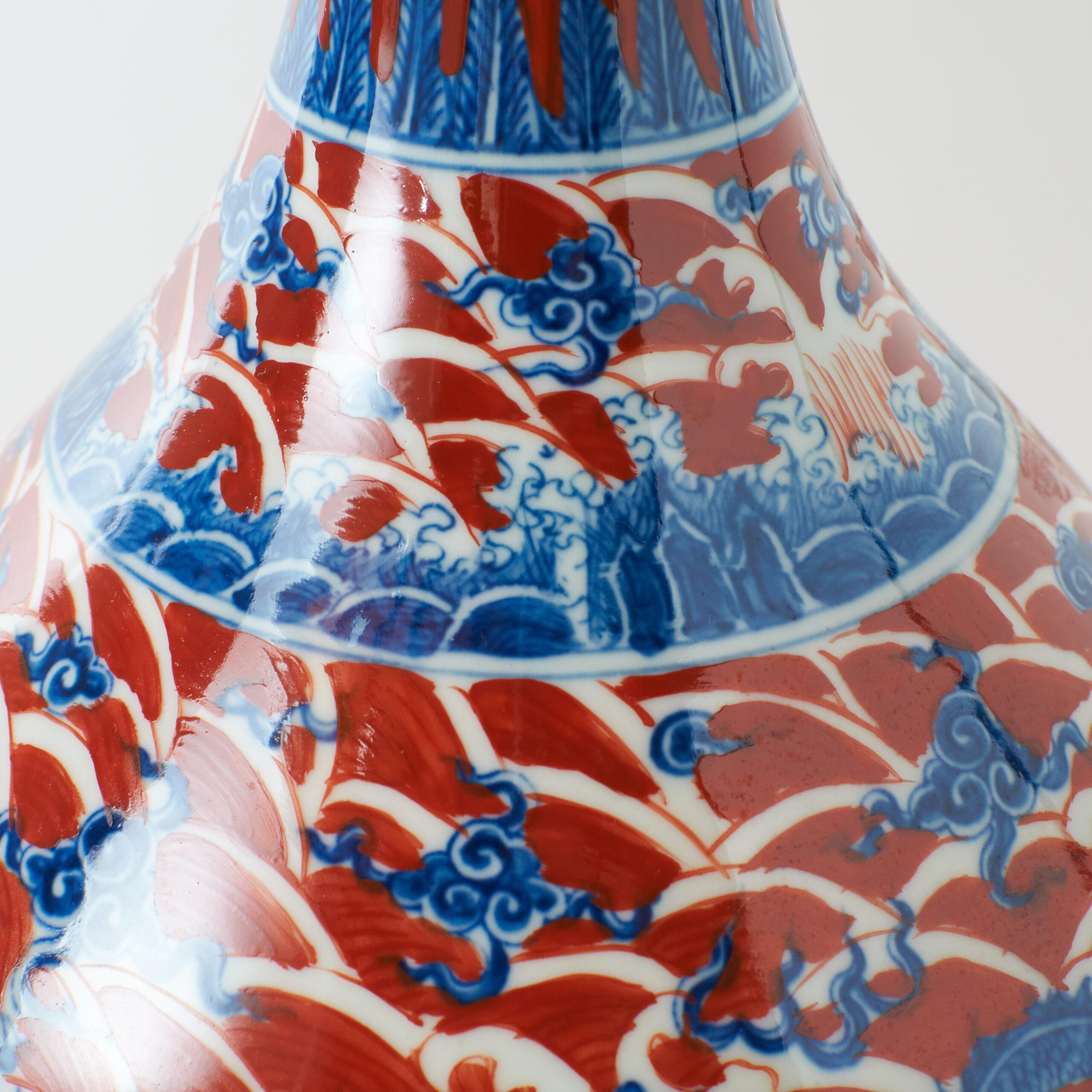 Porzellanvase mit Drachenmotiv im Yuhuchun-Stil

Eine birnenförmige chinesische Porzellanvase mit ausladender Mündung, abgerundetem Körper und schmalem Boden. Dekoriert mit rotem Grund und Wellenmustern in Blau und Weiß, zentriert durch ein