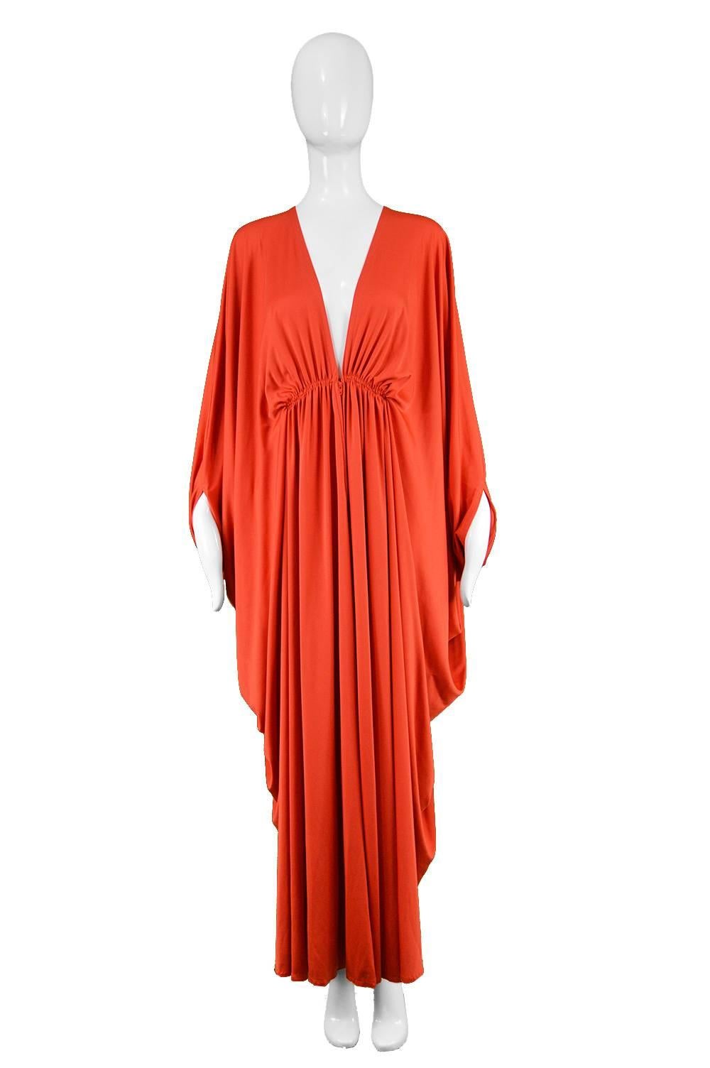 Yuki Vintage 1970s Draped Orange Jersey Maxi Caftan Dress

Estimated Size: XS to Medium due to stretch of inner waistband and kaftn silhouette. Please check measurements.
Bust - Free
Inner Waistband - Stretches up to 34” / 86cm
Hips - Free
Length