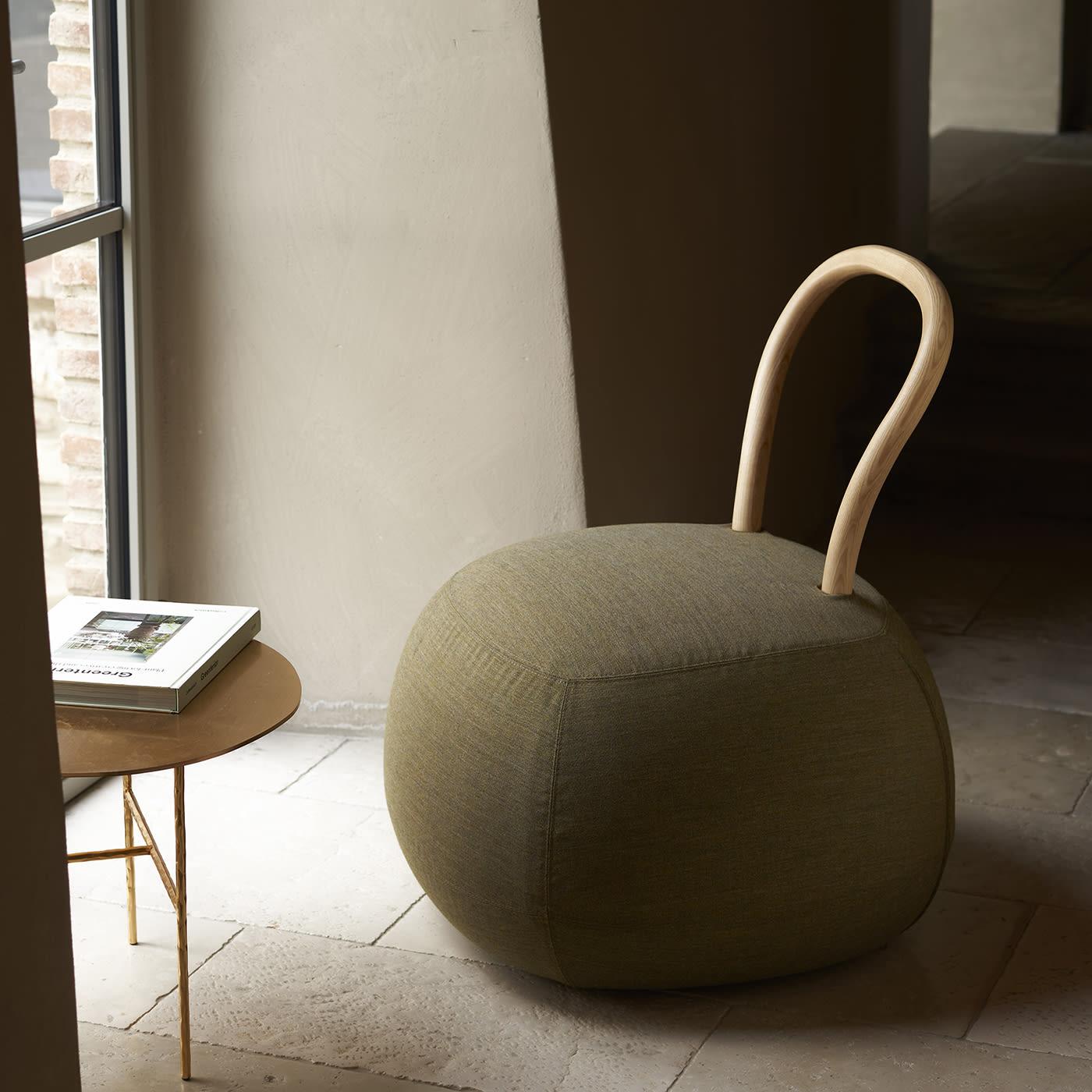 The encounter between a pouf and a chair led to this lively design, comprised of a generously stuffed rounded seat to which is fitted an essential and sinuous backrest in curved, whitened solid ash. Perfect to pamper a minimalist decor with a quiet