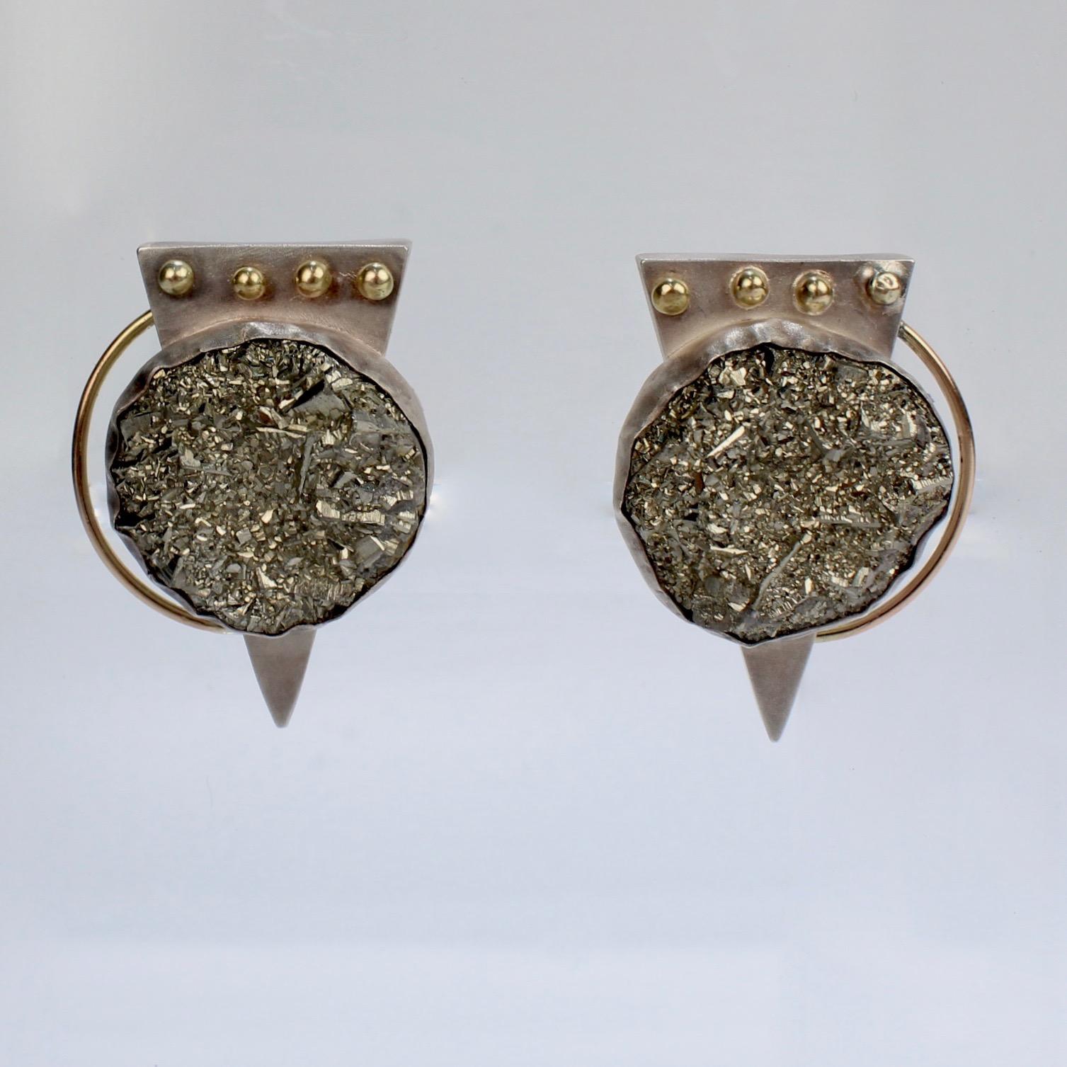 A great pair of modern, Memphis-style geometric earrings by Yumi Ueno.

Comprised of sterling silver and 14k gold and bezel set with large, circular pyrite cabochons atop triangular backs. Four gold spheres are set at the top of each triangle,