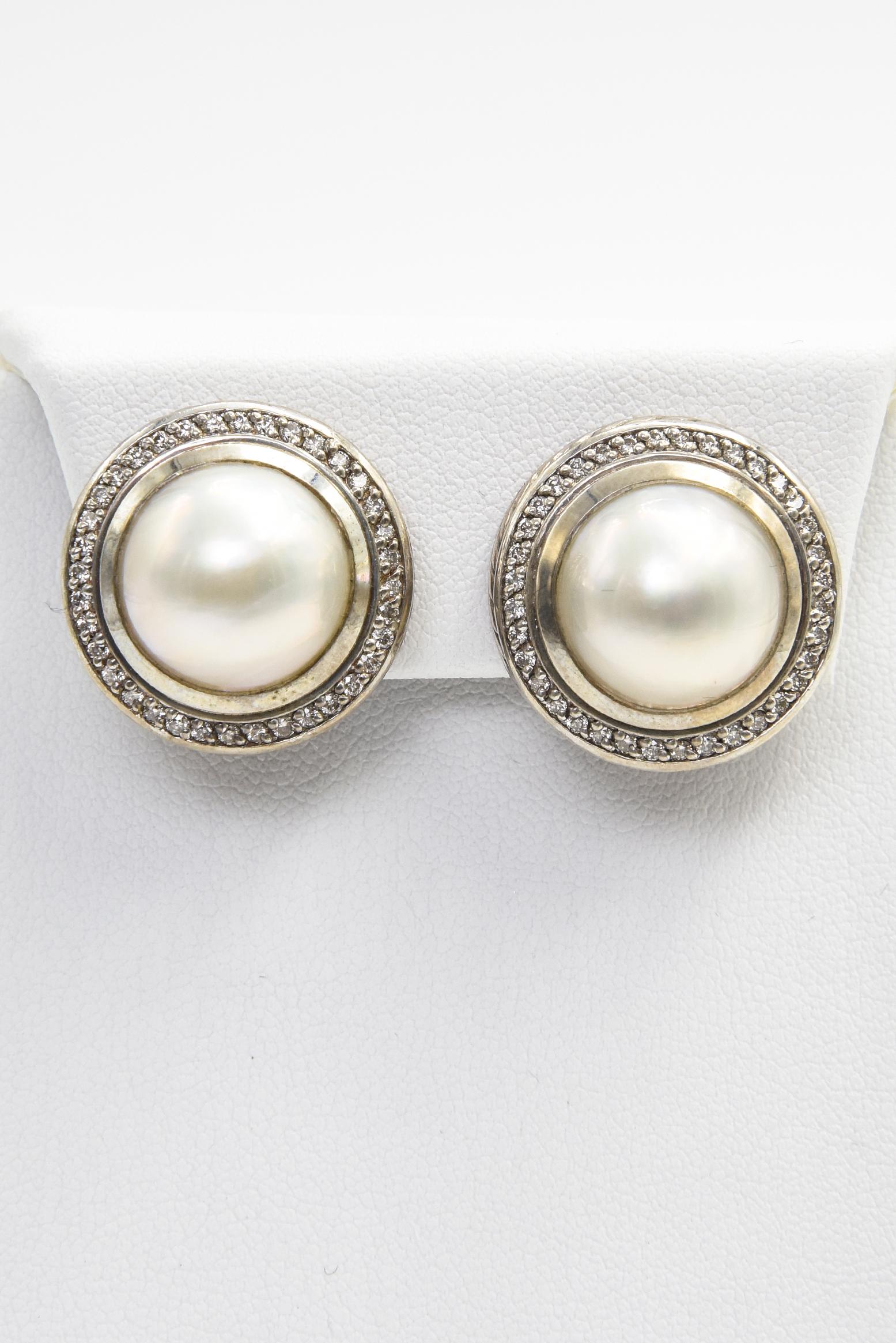 David Yurman sterling silver clip on earrings featuring a 14mm mabe pearl center in a diamond frame with a cable bezel outer rim.  They have approximately .72 carats in round cut diamond weight.  The back is a double omega clip on.  Marked DY 925 