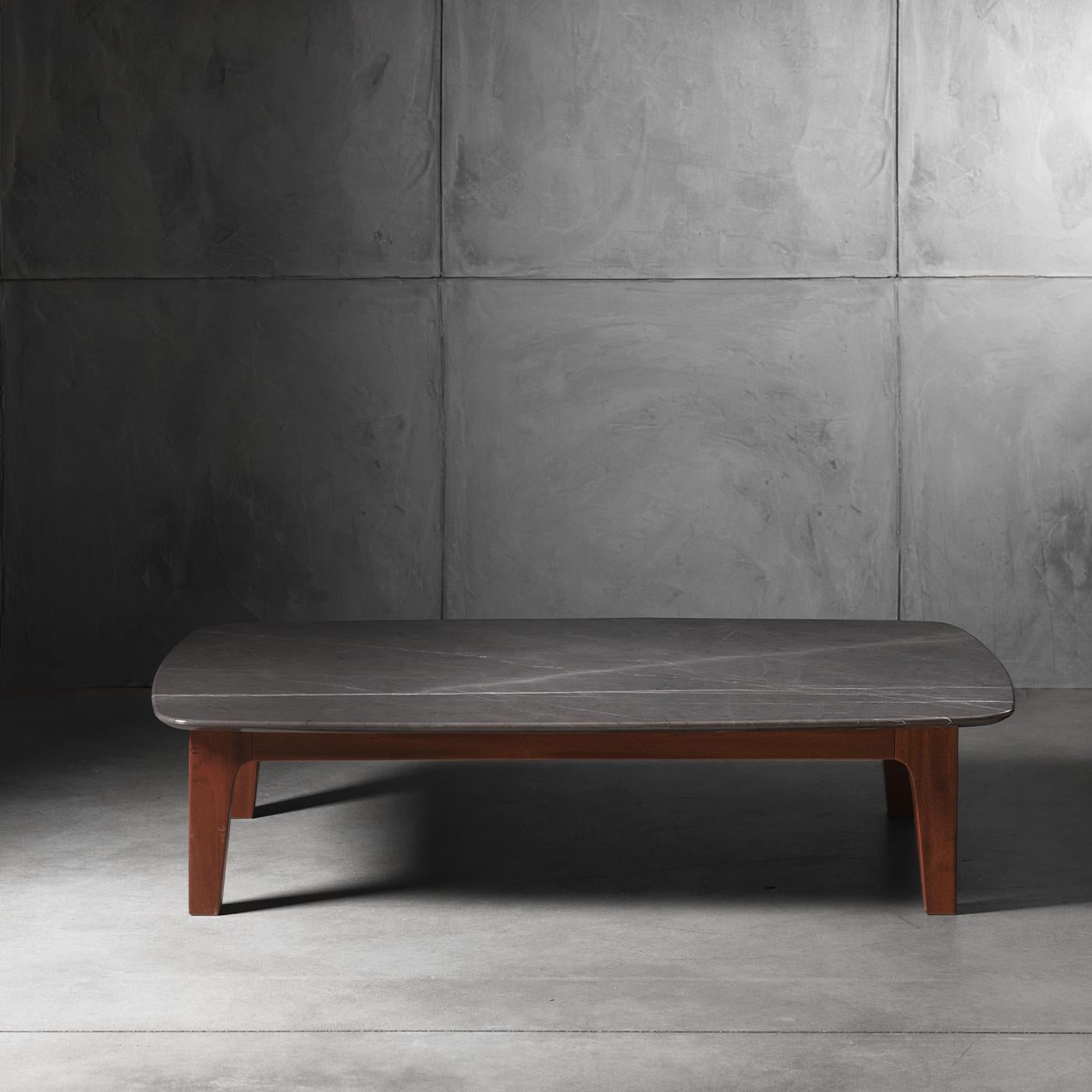 This low-sitting coffee table is part of the brand's Chelini Firenze collection that unites Made-in-Italy artisanal traditions with a modern look. Its sleek, minimalist silhouette is enhanced by a graphite top that sits upon Sipo Mahogany legs,