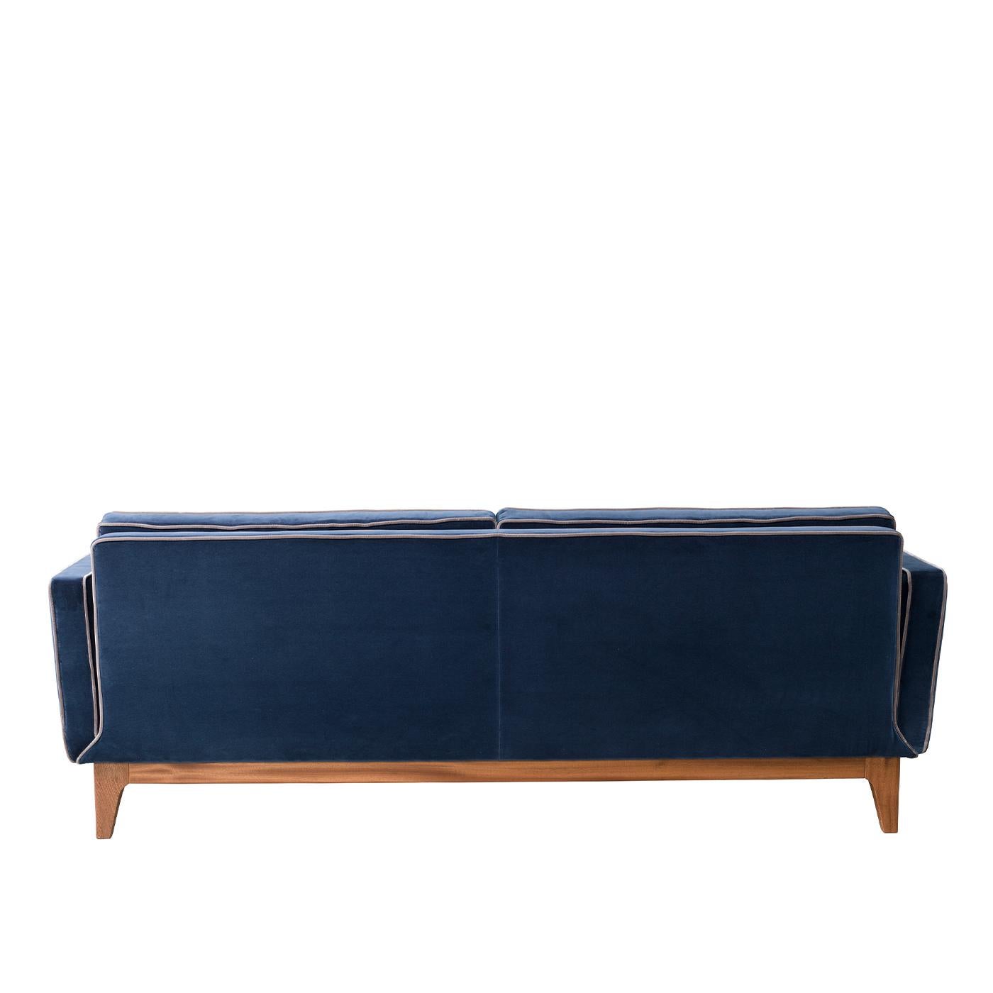 If you're looking to create a modern feel with traditional undertones, look no further than the Yvan Sofa. Supported by a solid mahogany base that channels mid-century influences, its deep blue velvet upholstery is accented with contrast trims and