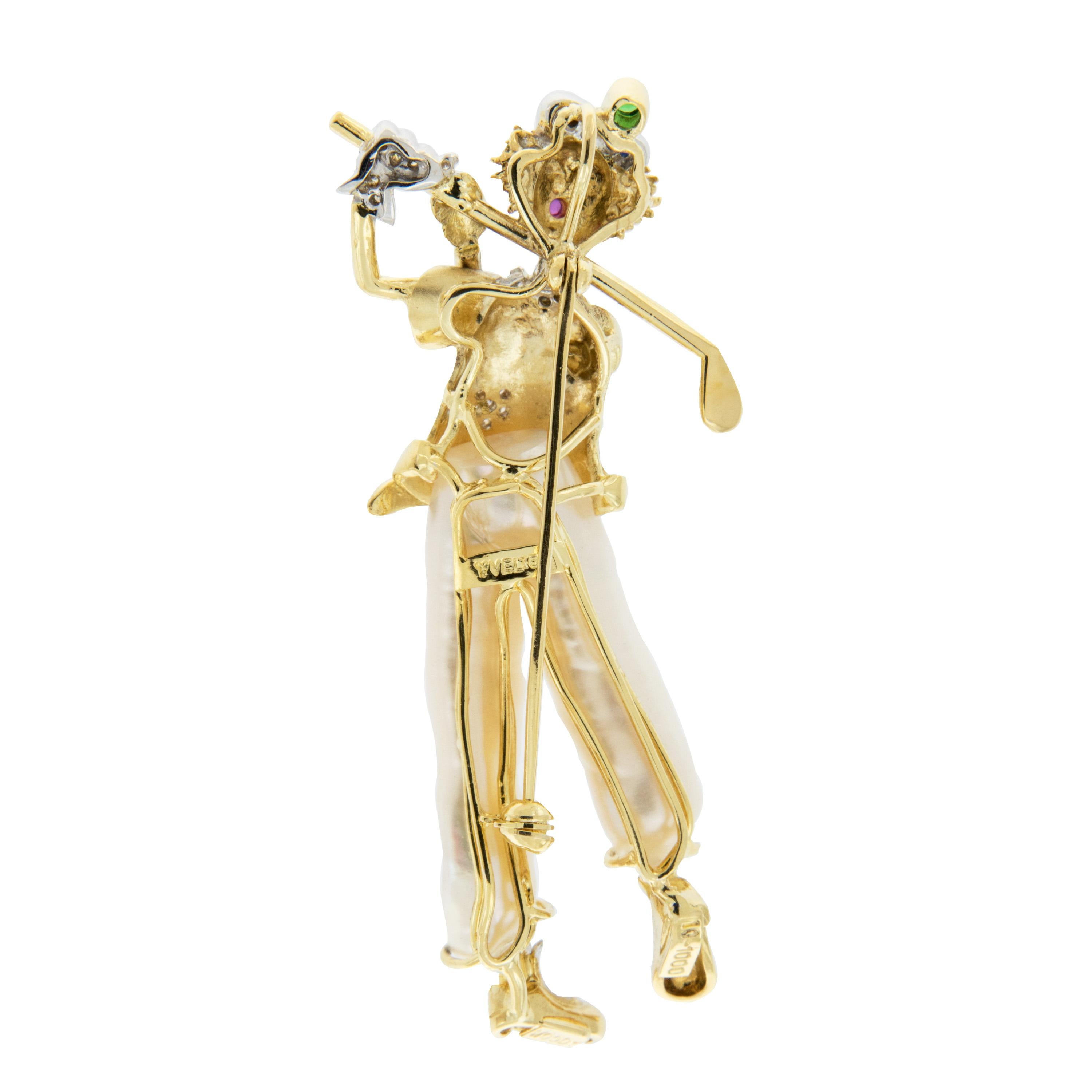 This charming pin is beautifully crafted in 18k yellow and white gold. The golfing clown is wearing freshwater pearl pants and diamonds on his shoes, glove, shirt and belt. Accented by twinkling ruby, sapphire and emerald stones. Marked YVEL. Weighs
