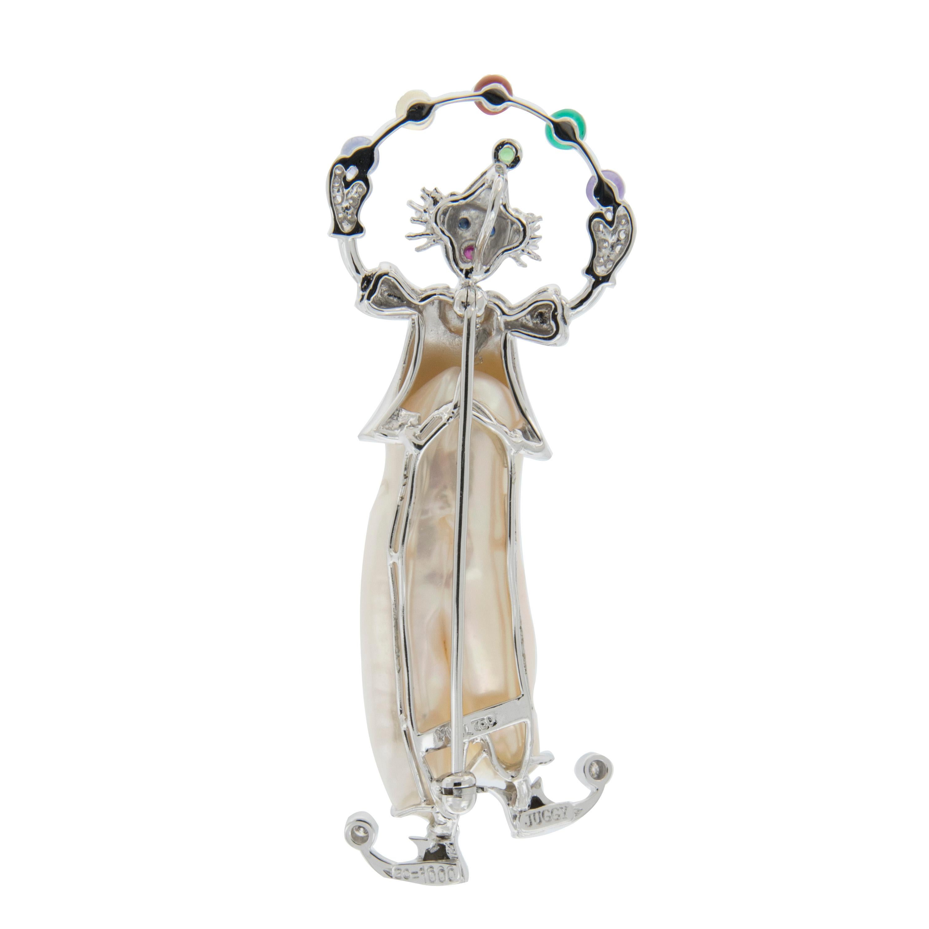 This charming pin is beautifully crafted in 18k white gold. the clown is wearing a freshwater pearl suit and diamonds on the toes, hands and suit. Accented with multi-colored gemstones. Marked YVEL. Weighs 16.4 grams.

Diamonds 1.0 cttw
