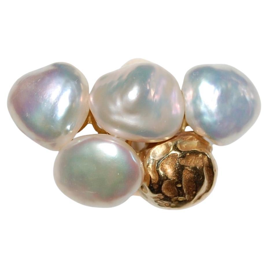 Yvel 18K Gold Sea Baroque Pearls Ring
Yvel's signature, handmade 18k yellow gold, polished-finish is combined with a beautiful four baroque pearls and one gold in the shape of a fifth pearl. Each pearl in unique in a different beautiful shades of