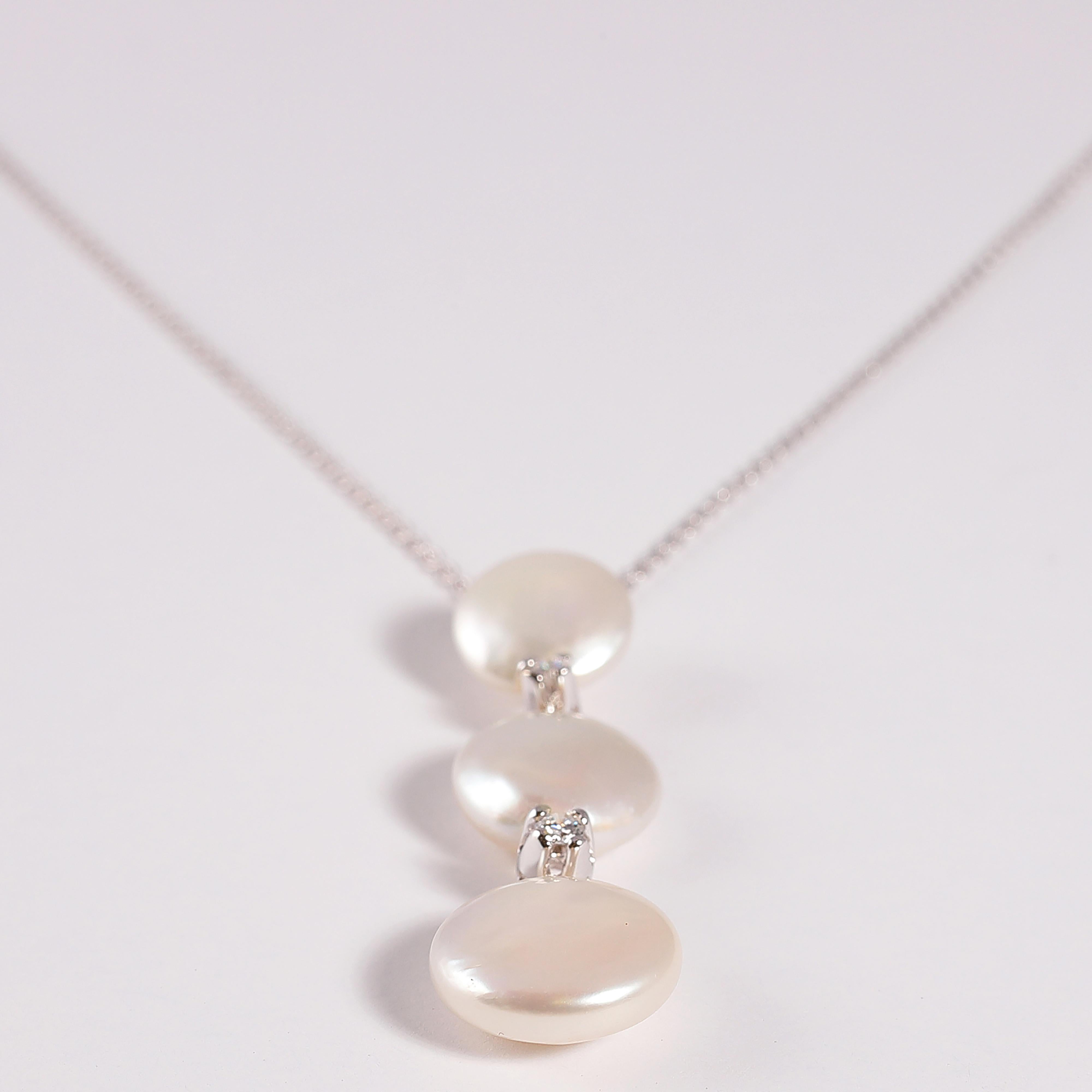 This 18 karat white gold, 16 1/4 inch chain suspends a white gold drop measuring 1 1/2 inches that supports three Biwa cultured pearls and two round diamonds, all by famed designer Yvel!  